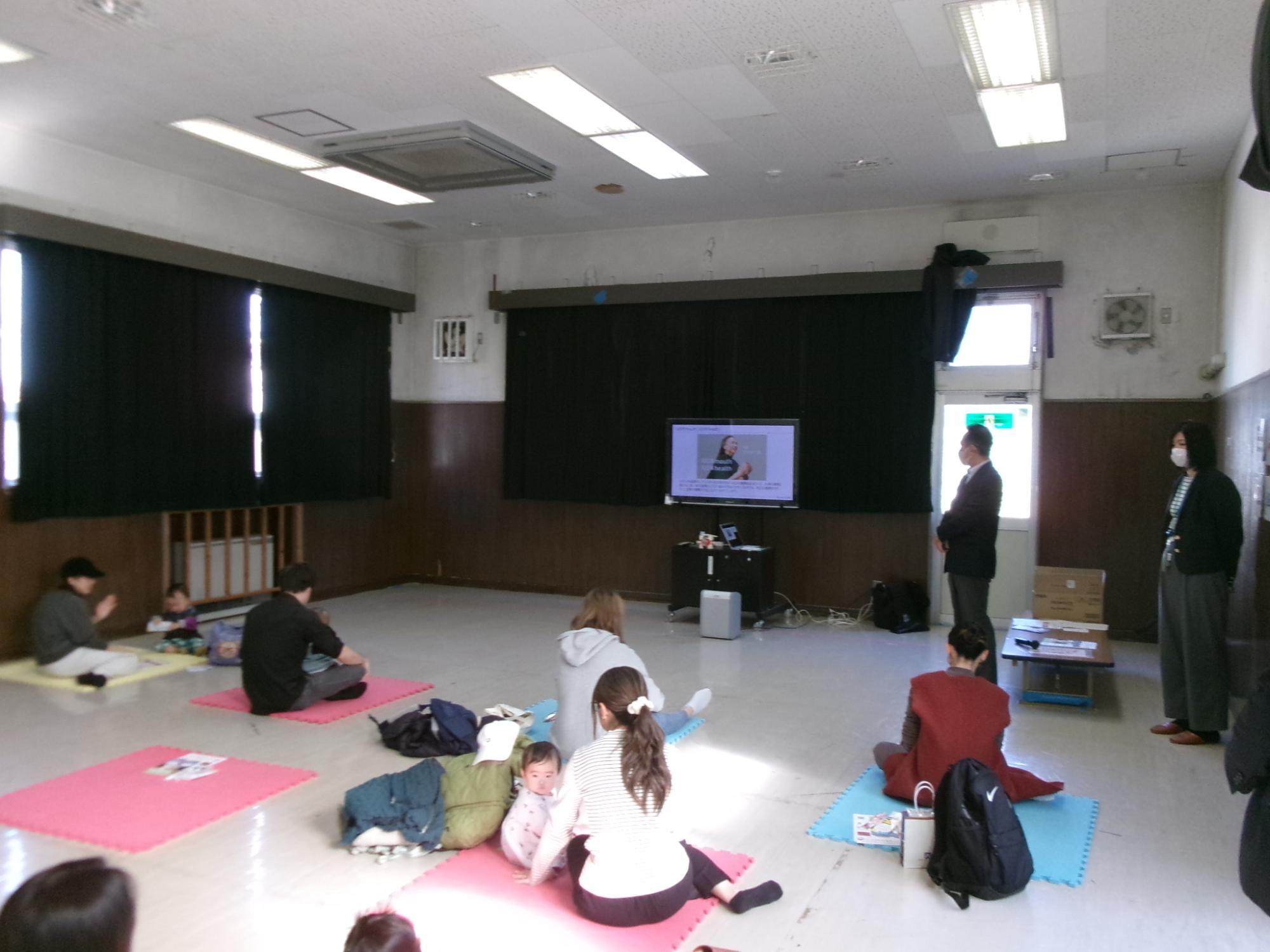 乳幼児親子が歯科衛生士によるセミナーに参加している様子の写真