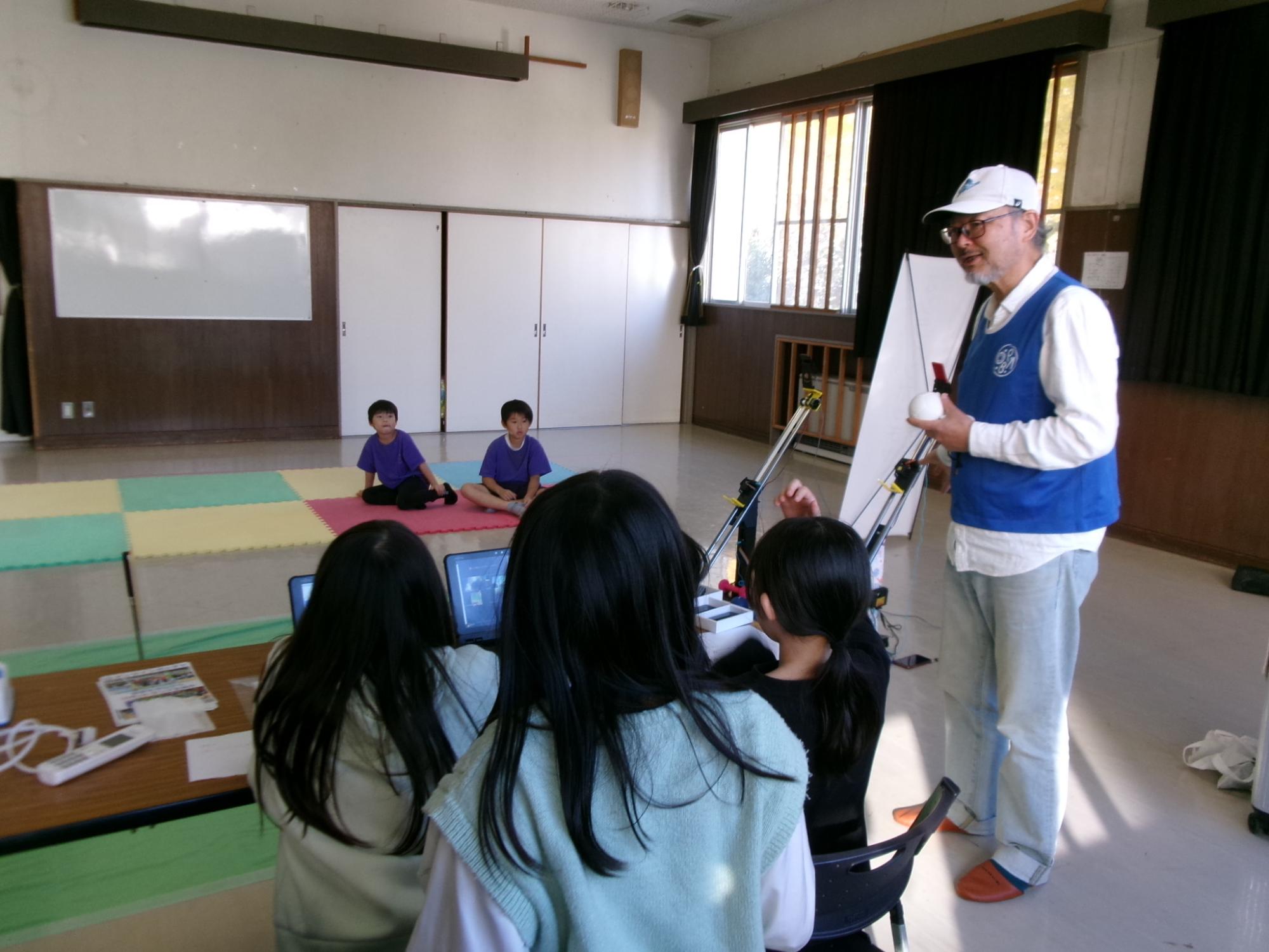 小学生がボッチャのルールやオンラインボッチャの操作方法を講師に教えてもらっている様子の写真