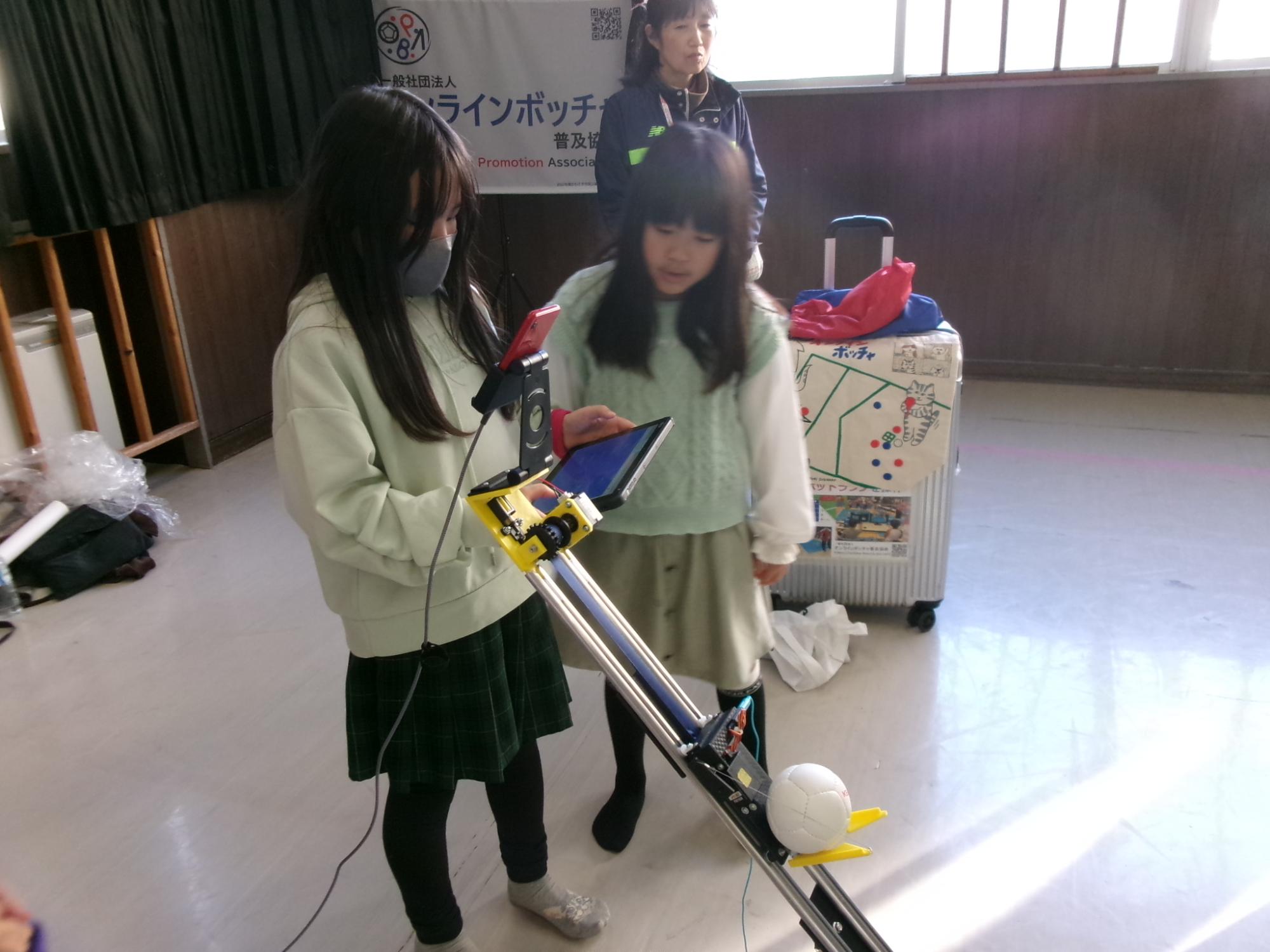 小学生がオンラインボッチャの機械を操作している様子