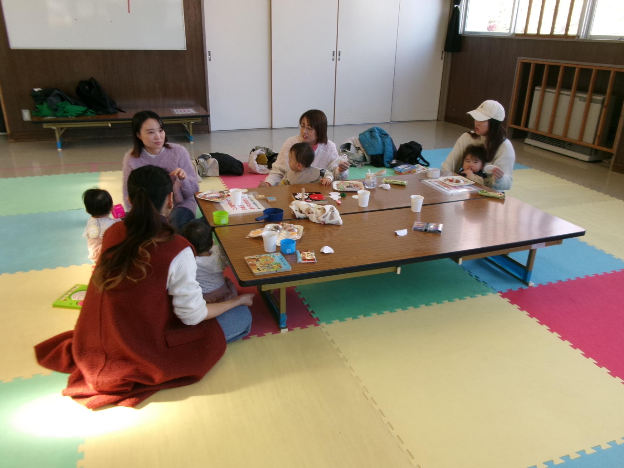 飲み物を飲みながら談笑している幼児親子の写真