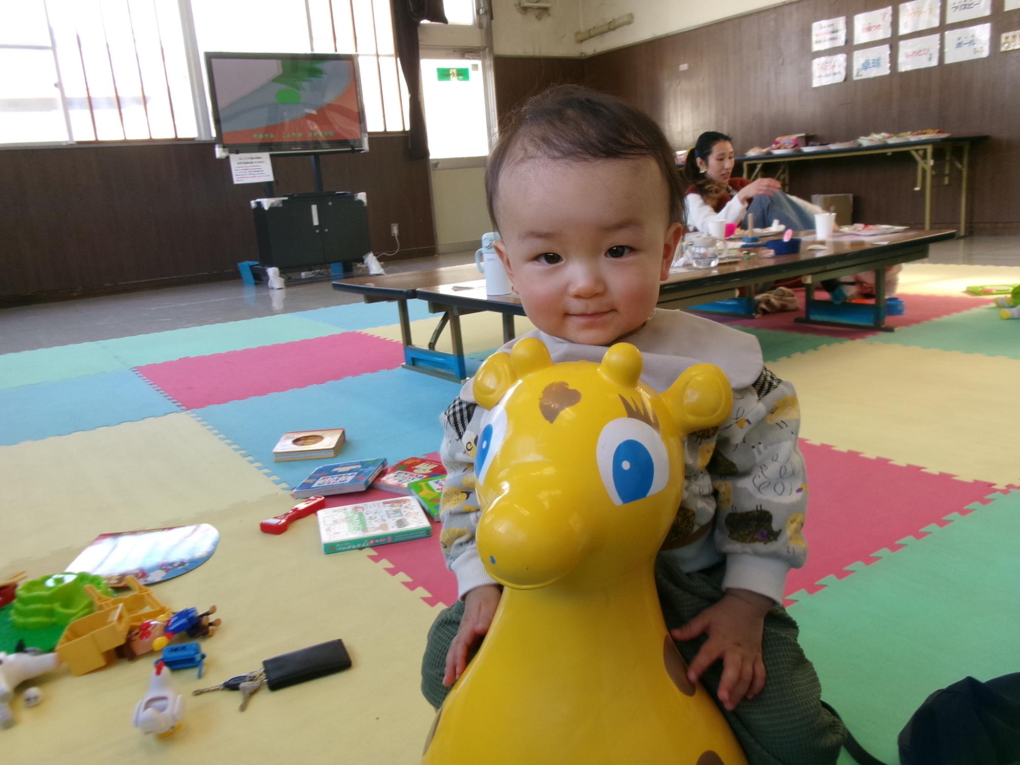 乗ることができるおもちゃに乗って楽しんでいる様子の幼児の写真