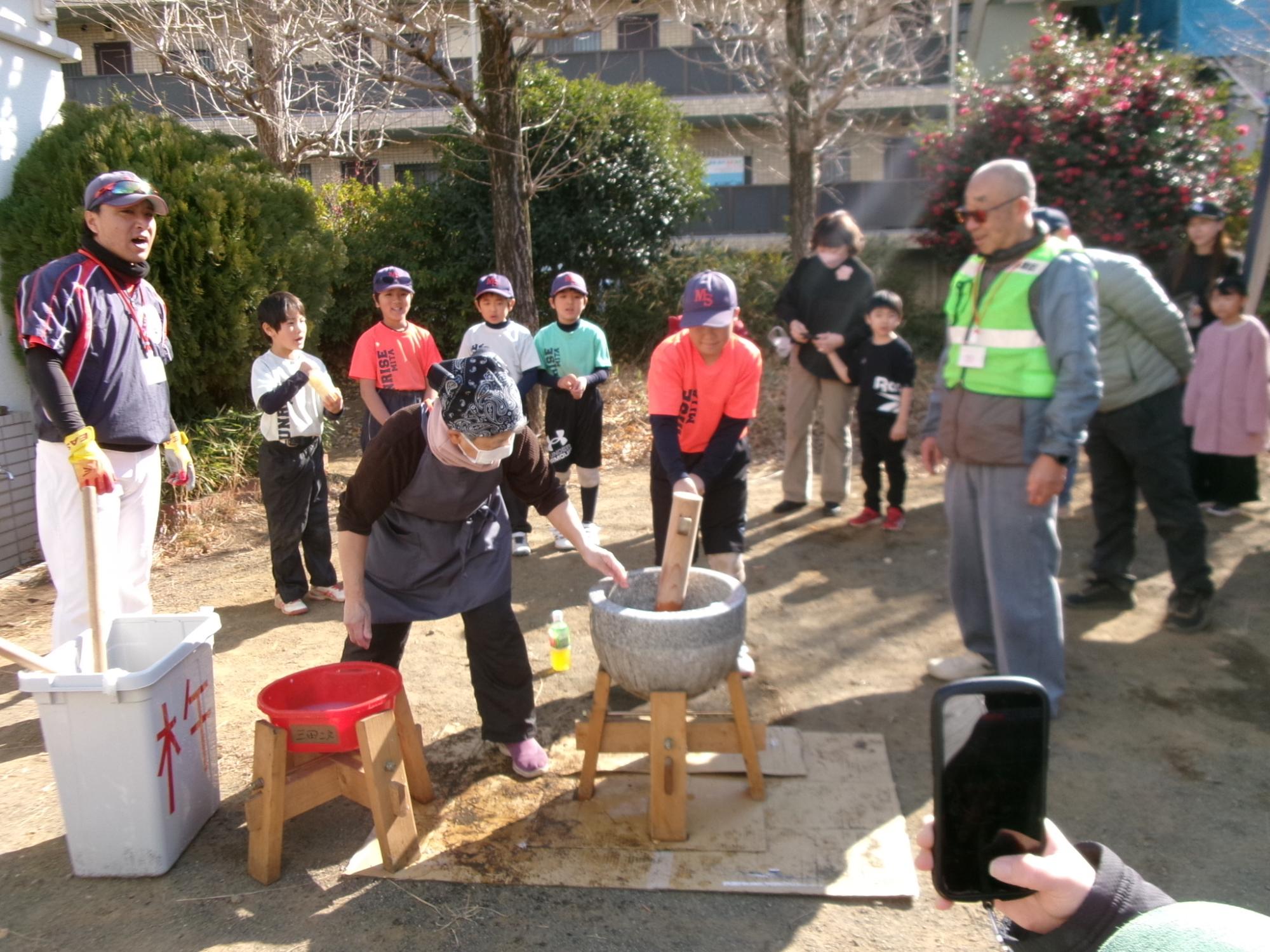 もちつきの体験をしている子どもの様子と地域の方々の写真
