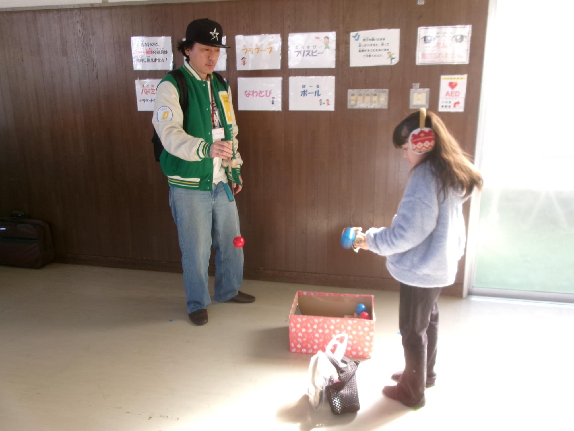 地域の方とけん玉を楽しむ子どもの写真