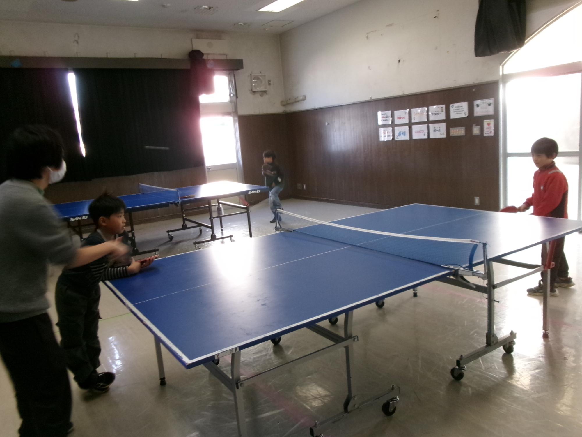 職員から卓球を教わっている子どもの写真