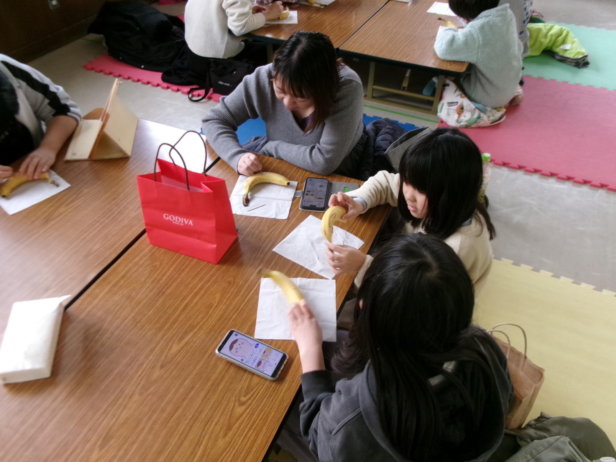 親子でバナナアートを体験している様子の写真