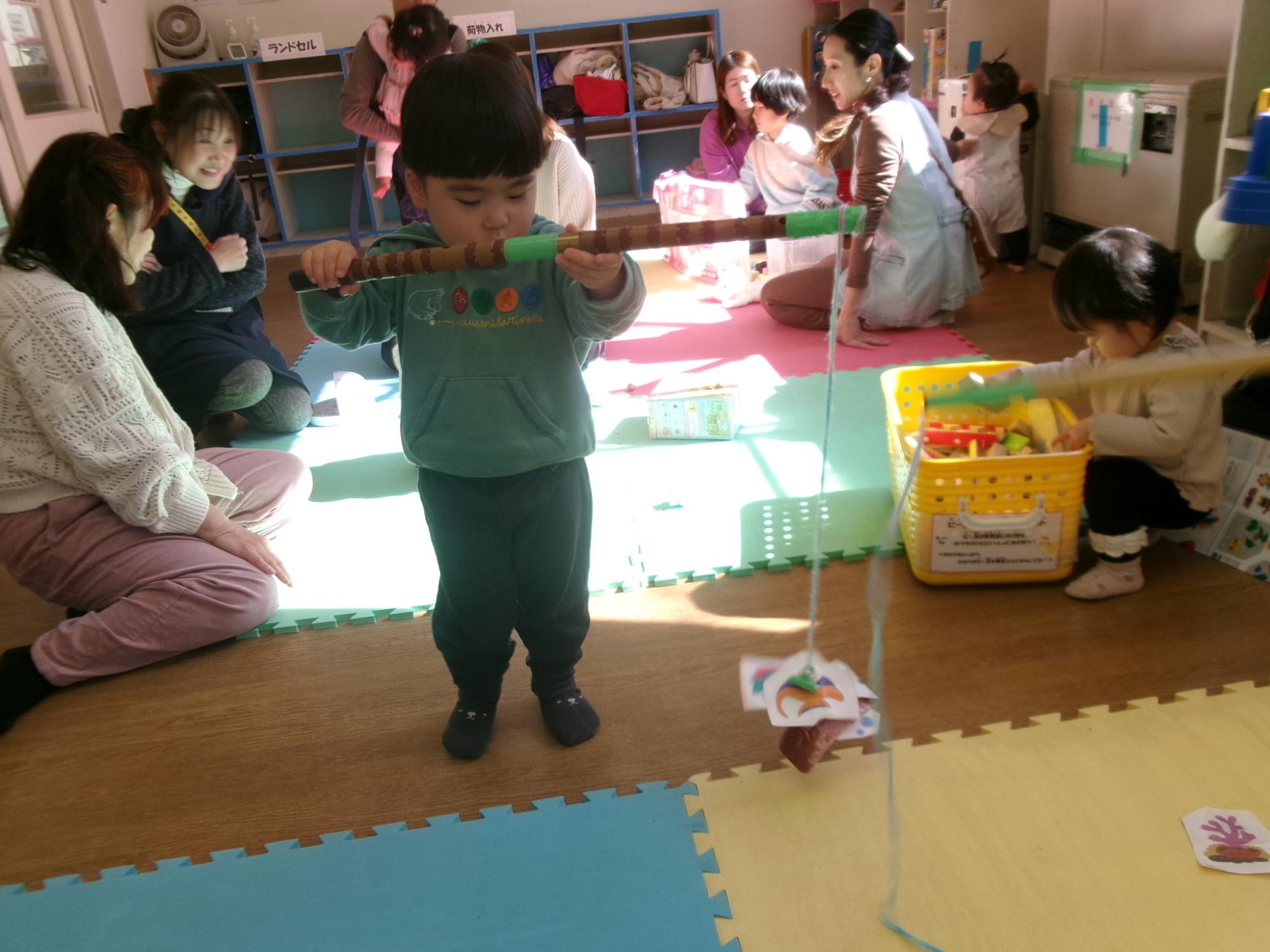 魚釣り遊びをする幼児の写真