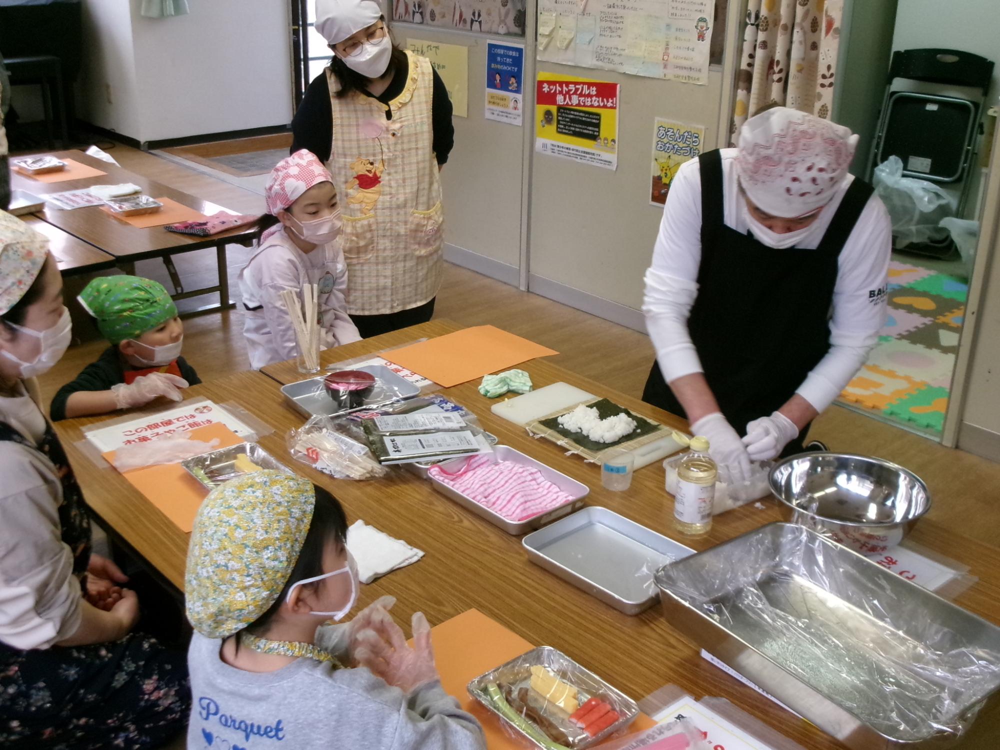 講師が太巻きの作り方を実演している様子の写真
