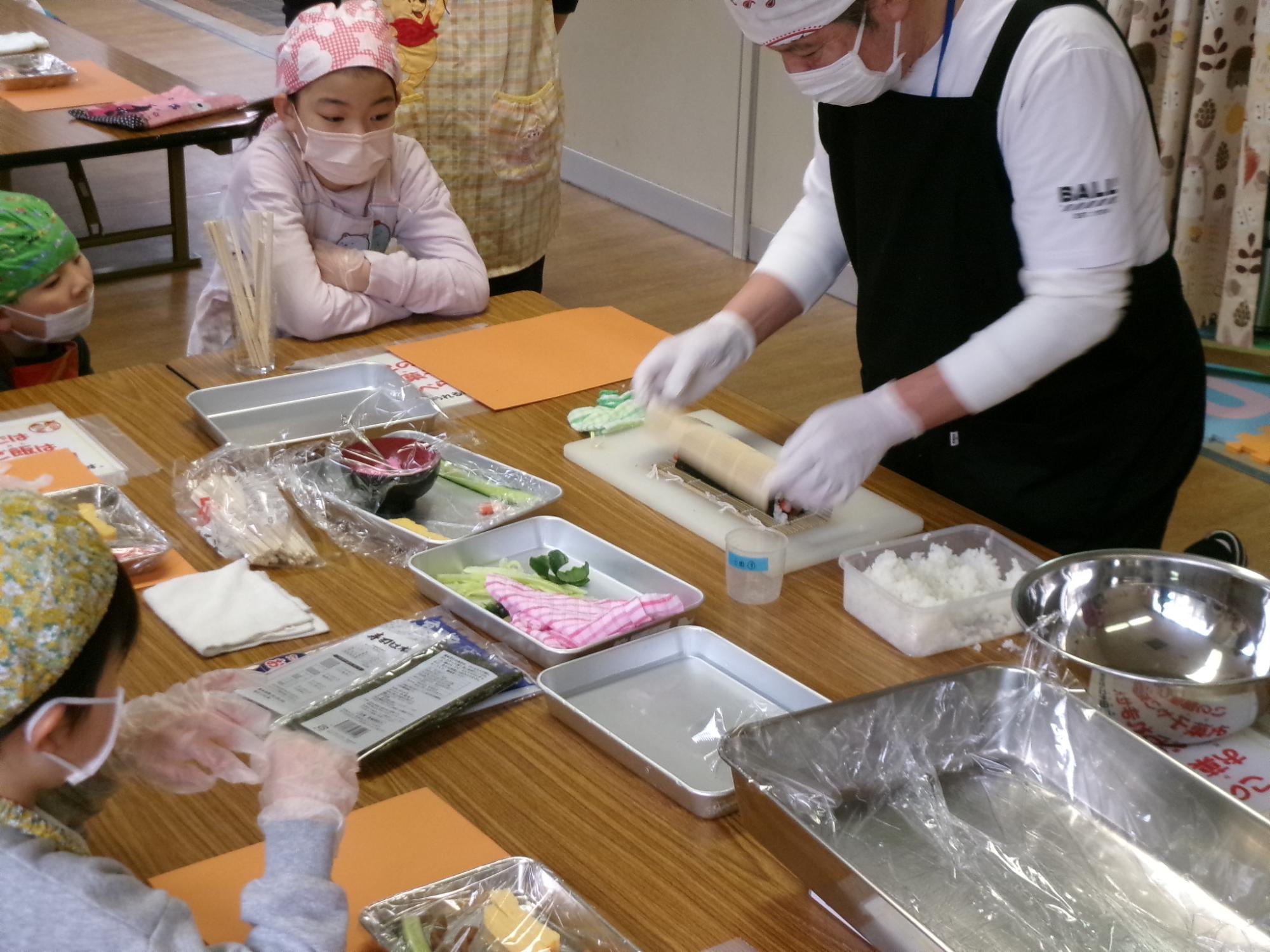 巻きすを使って太巻きを作っている講師の写真