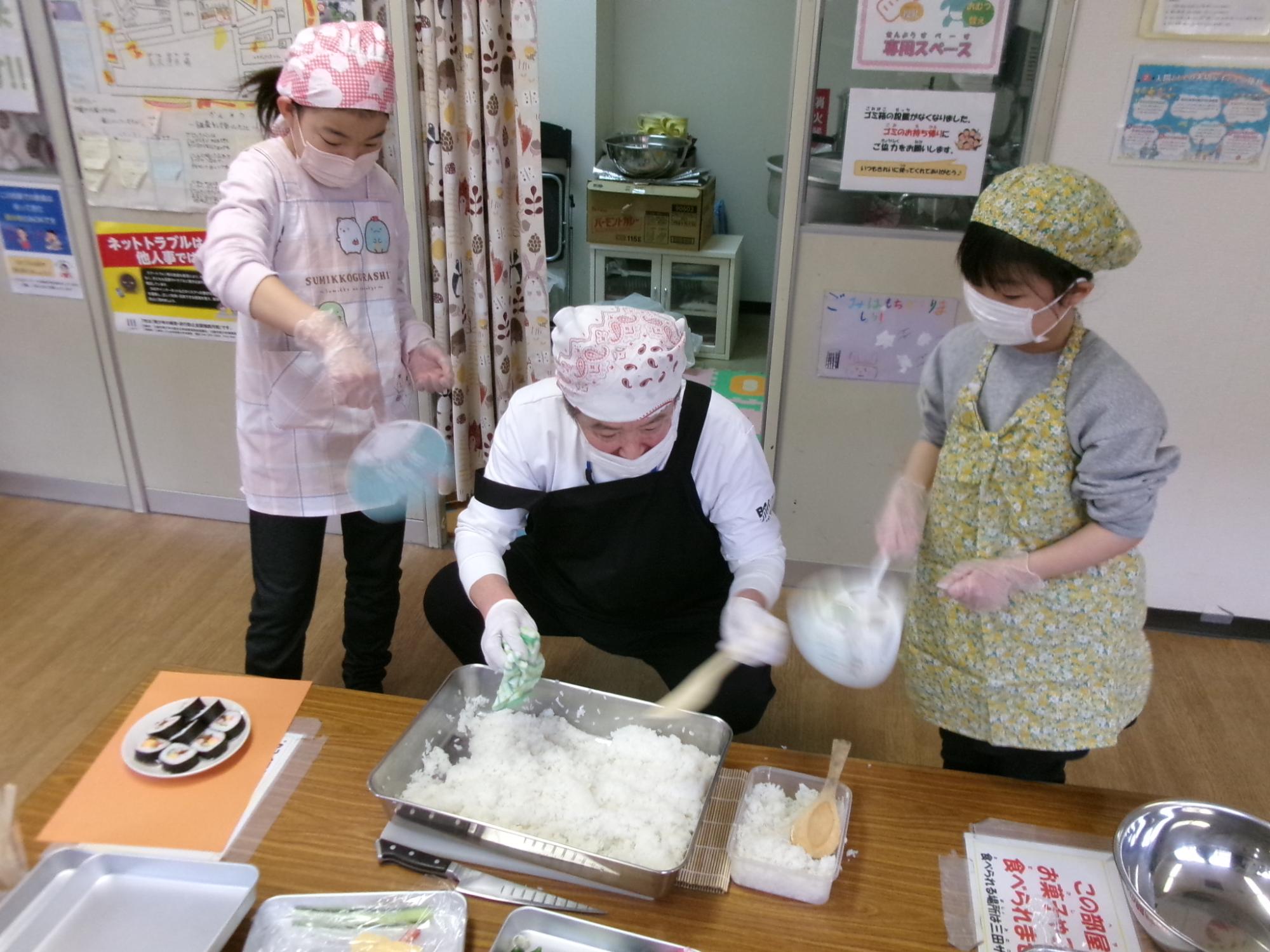 参加児童がうちわでお米を冷やしている様子の写真