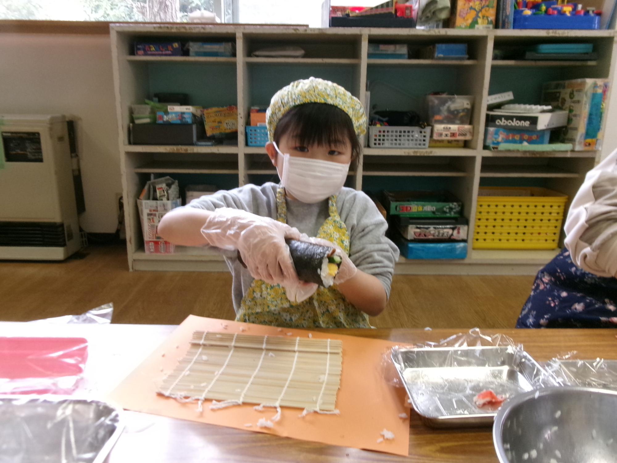 完成した太巻きを持っている児童の写真