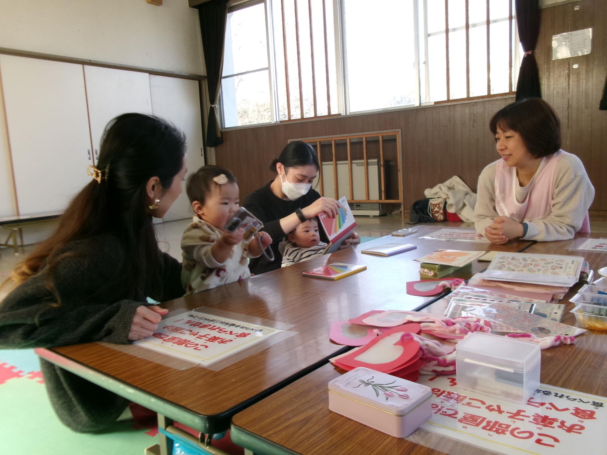 工作の紙を選んだり、遊んでいる幼児親子の様子の写真