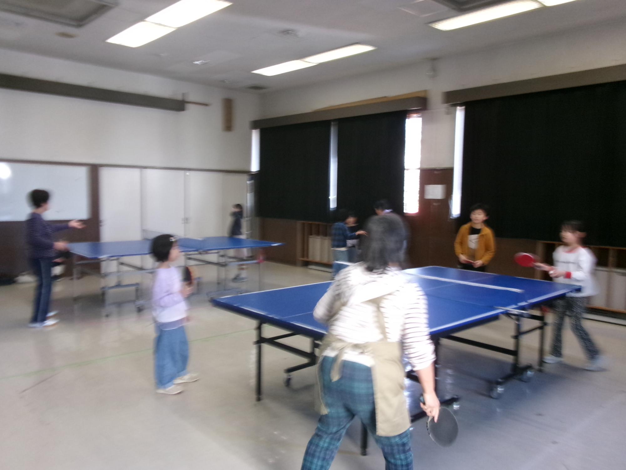 卓球をしている参加者と会場の様子の写真