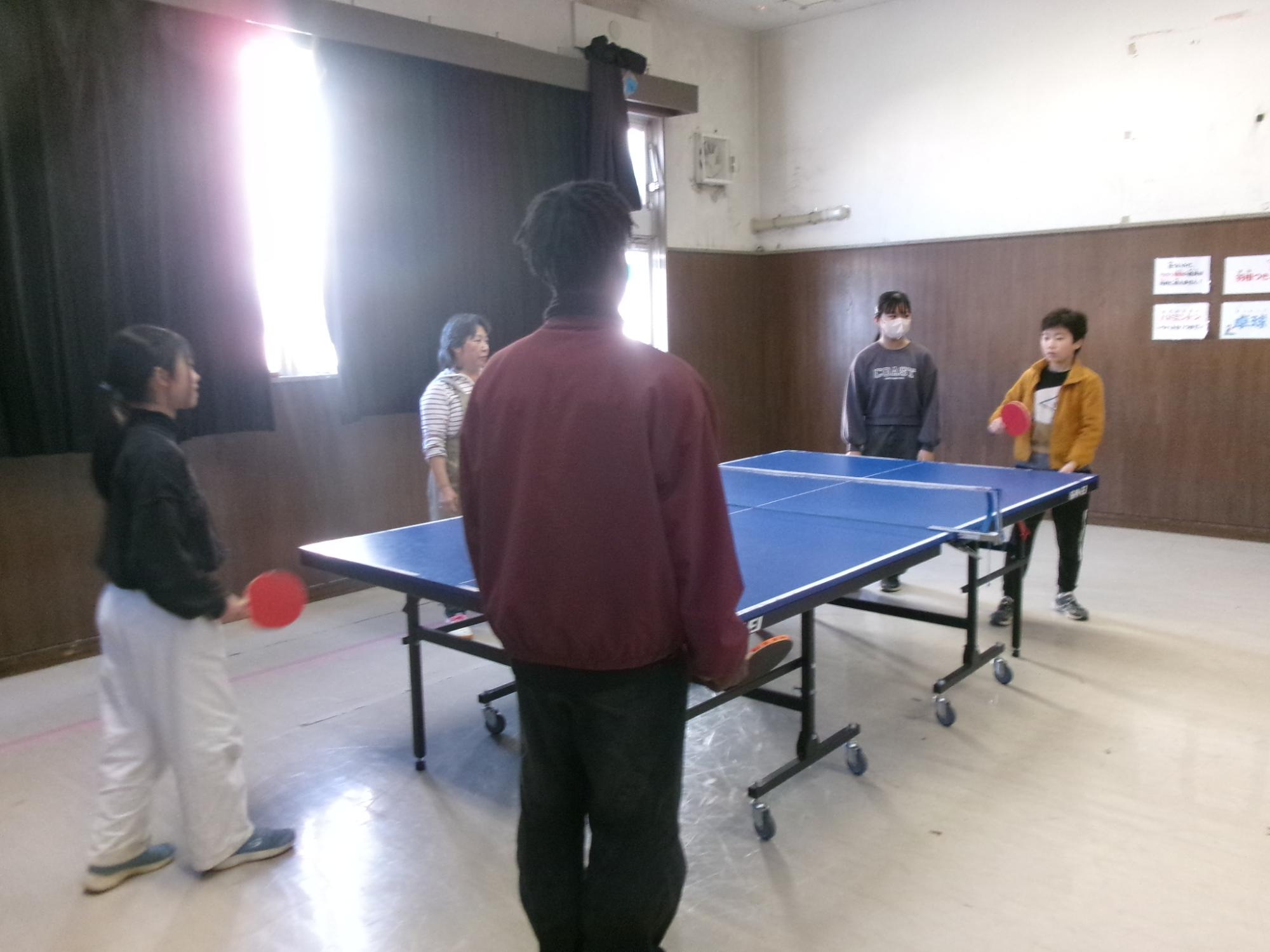 大学生ボランティアと一緒に卓球をしている参加者の写真