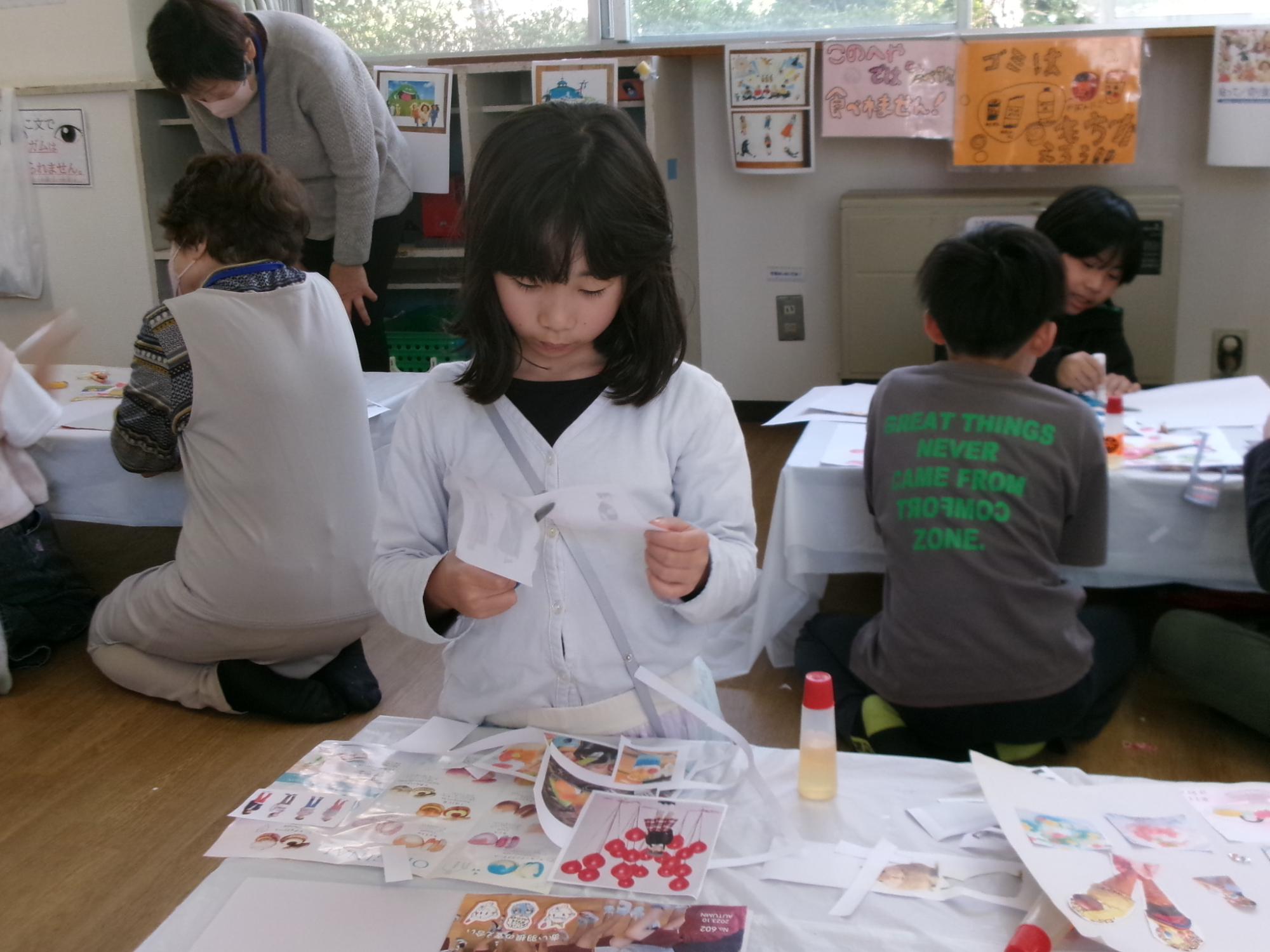 児童がコラージュ工作の素材を切り取っている様子