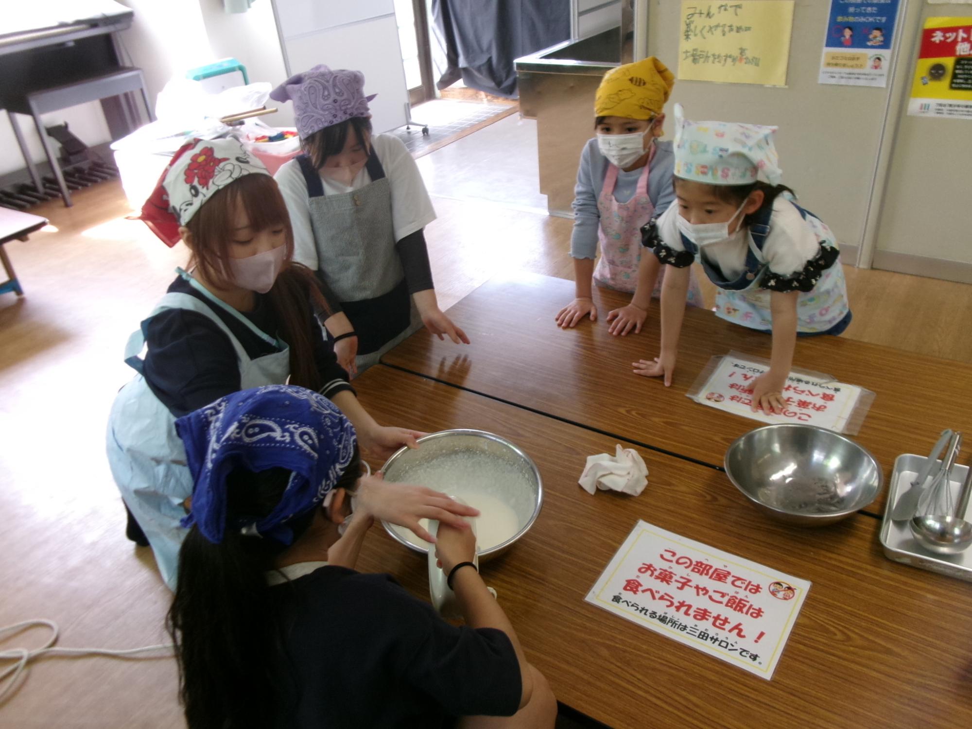 いちごのムース作りで泡だて器を児童が使用している様子