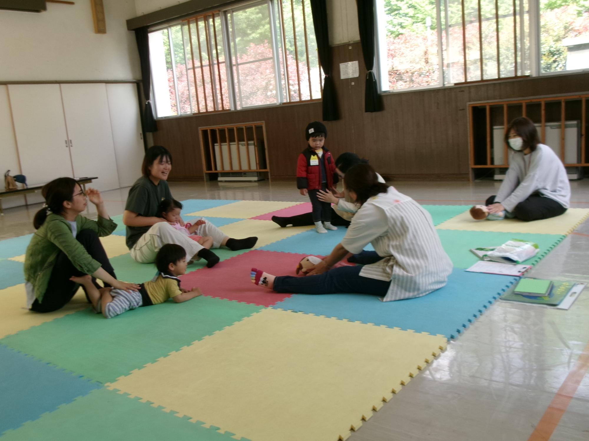 乳幼児親子が講師と一緒に親子でふれあい遊びをしている様子