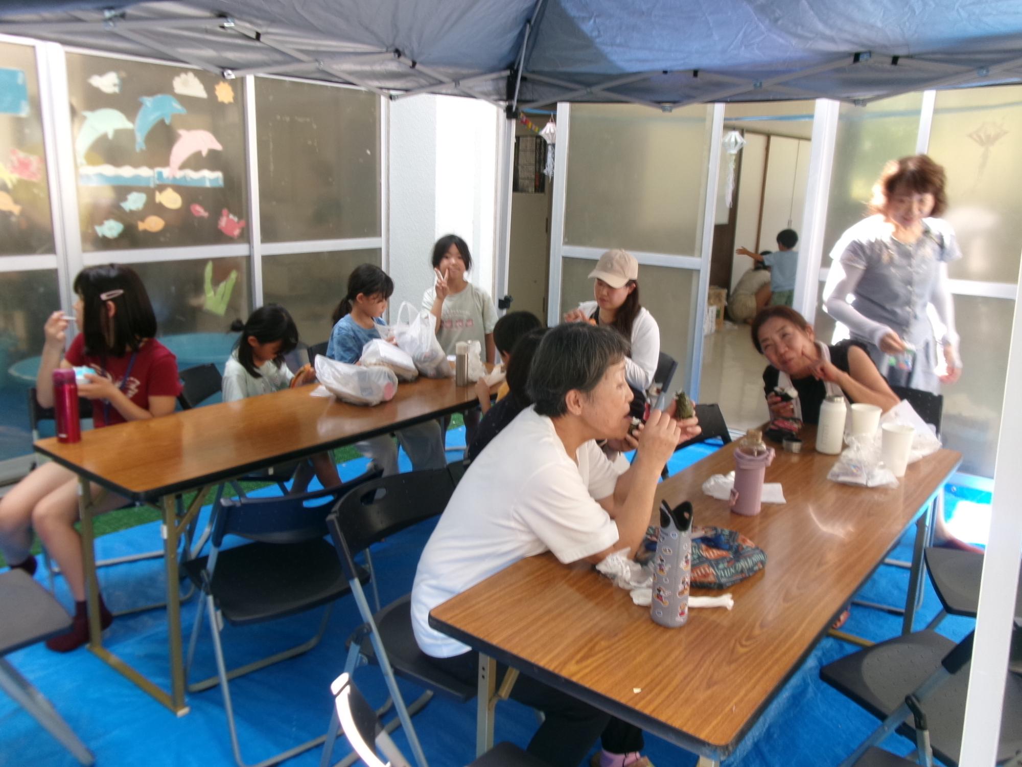 中庭の飲食スペースで楽しそうに飲食している参加者の様子の写真