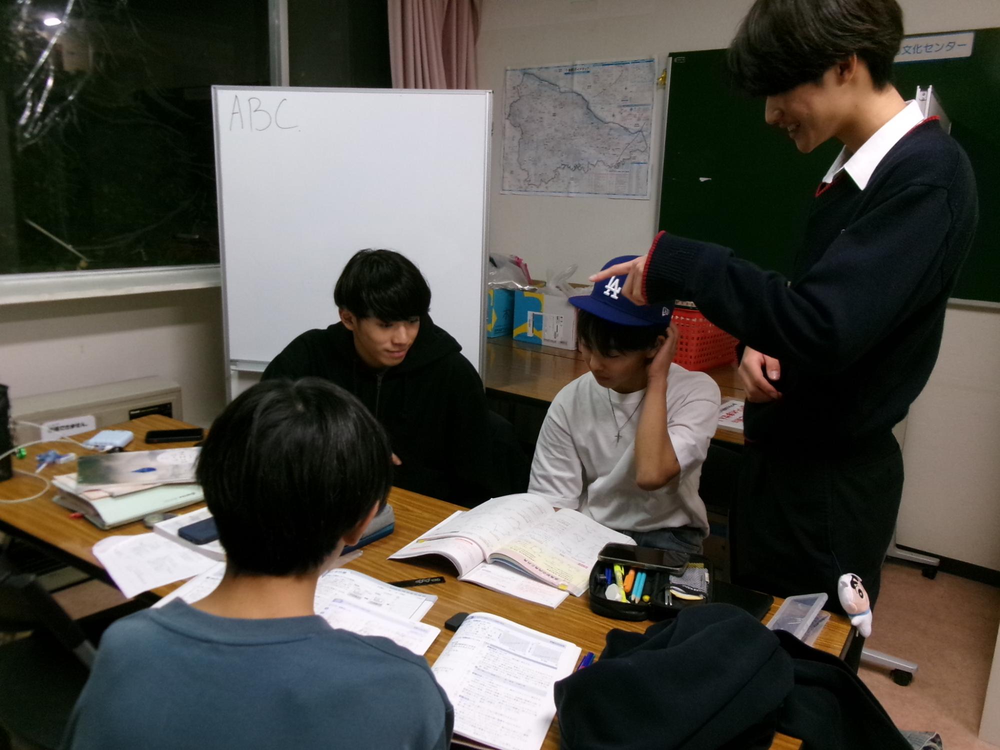 高校生が中学生に勉強を教えている様子の写真