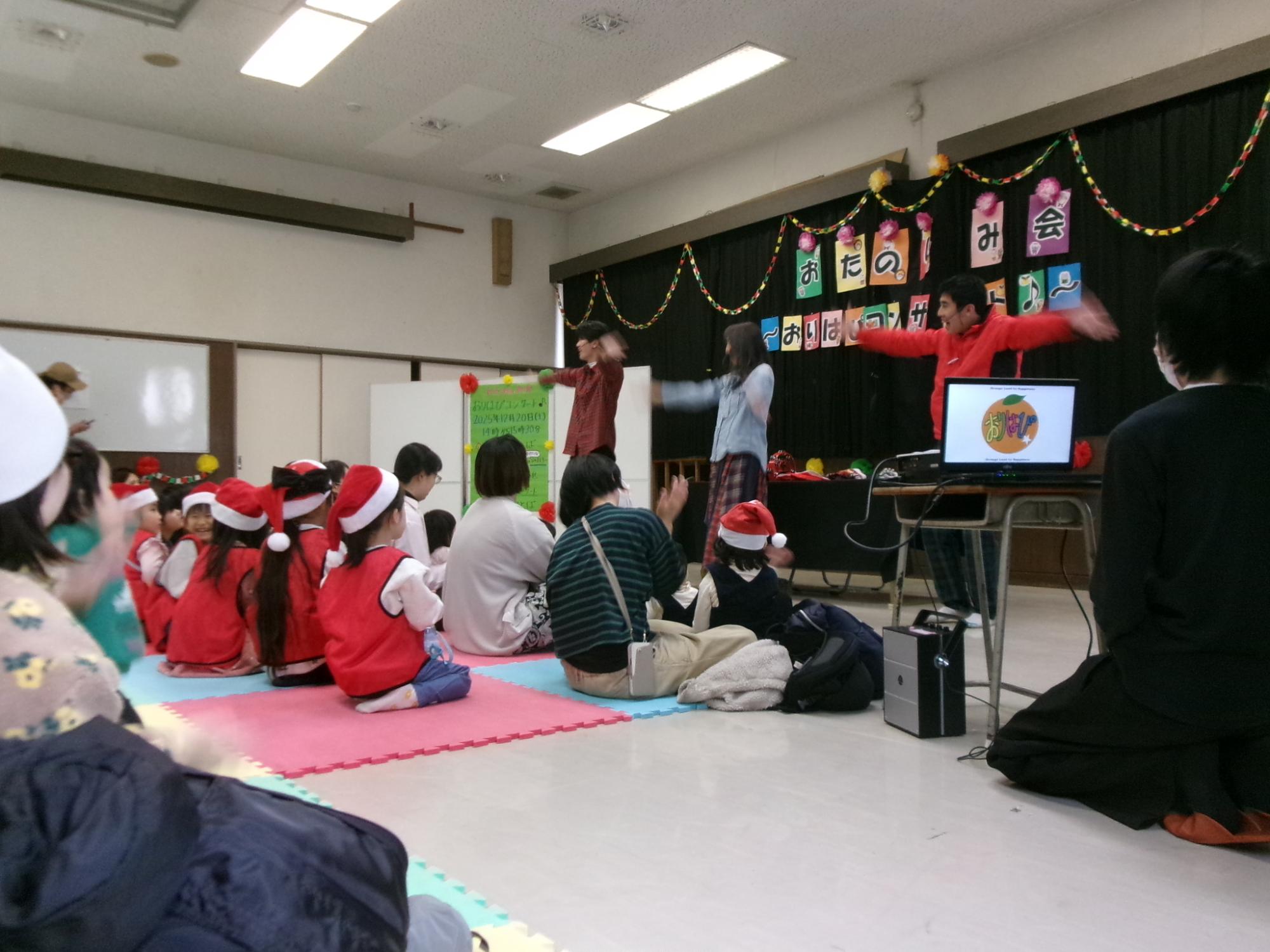 お兄さん、お姉さんの歌を聞いている参加者の様子の写真