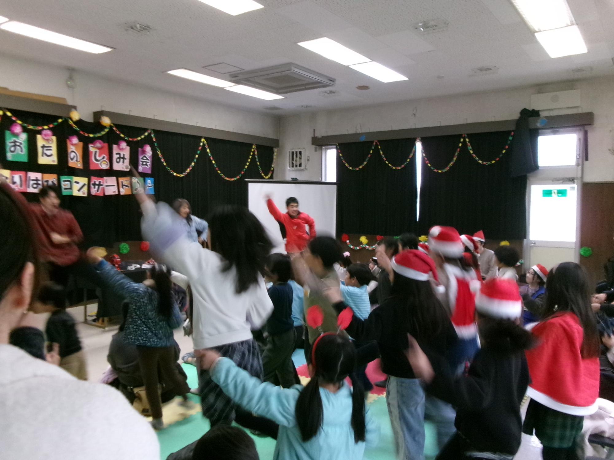 お兄さん、お姉さんと一緒にみんなでダンスを踊っている様子の写真