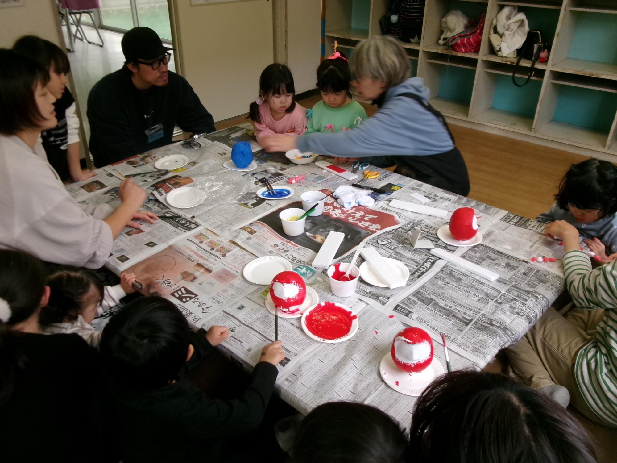 だるまの絵付けをしているこどもたちの写真