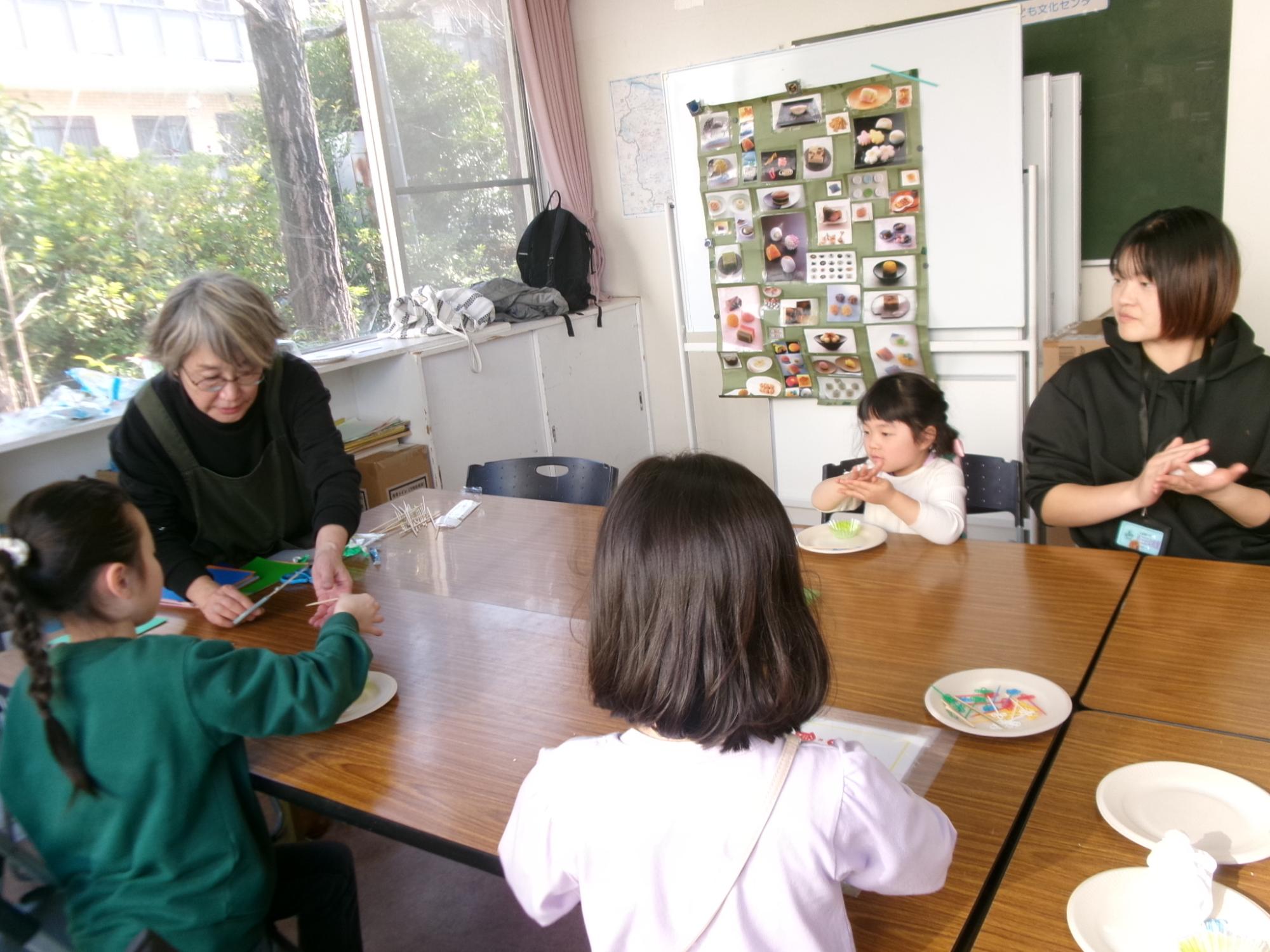 児童が講師に工作を教わり和菓子の工作をしている様子