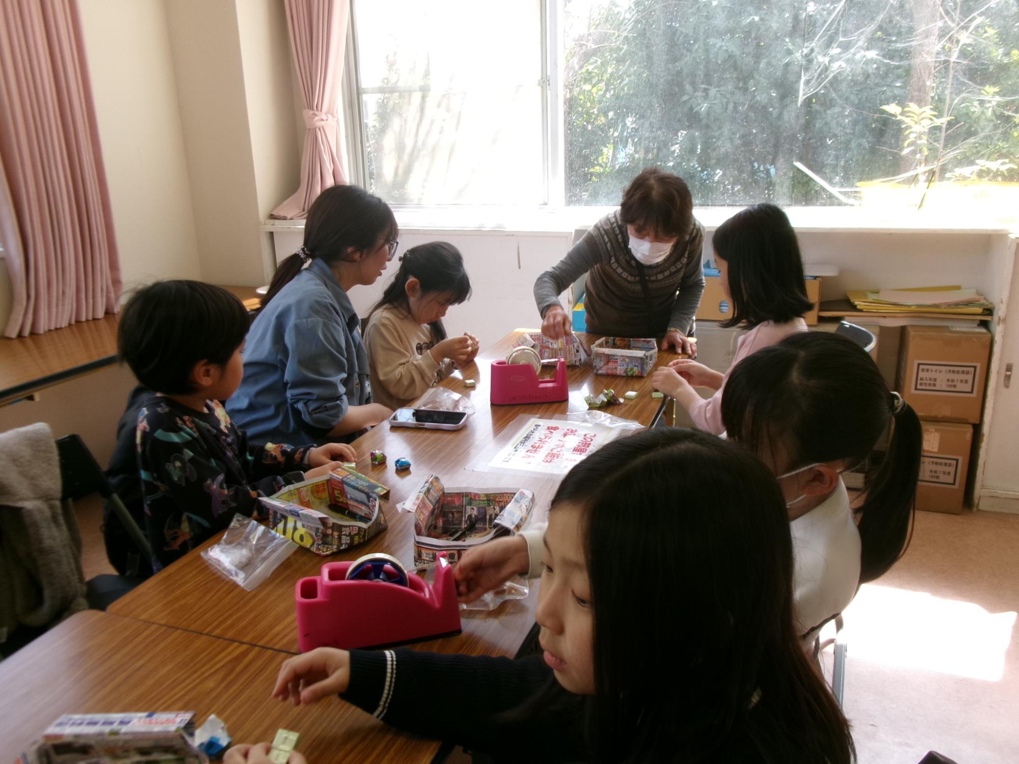 児童と幼児親子がチョコ型マグネットを作成している様子