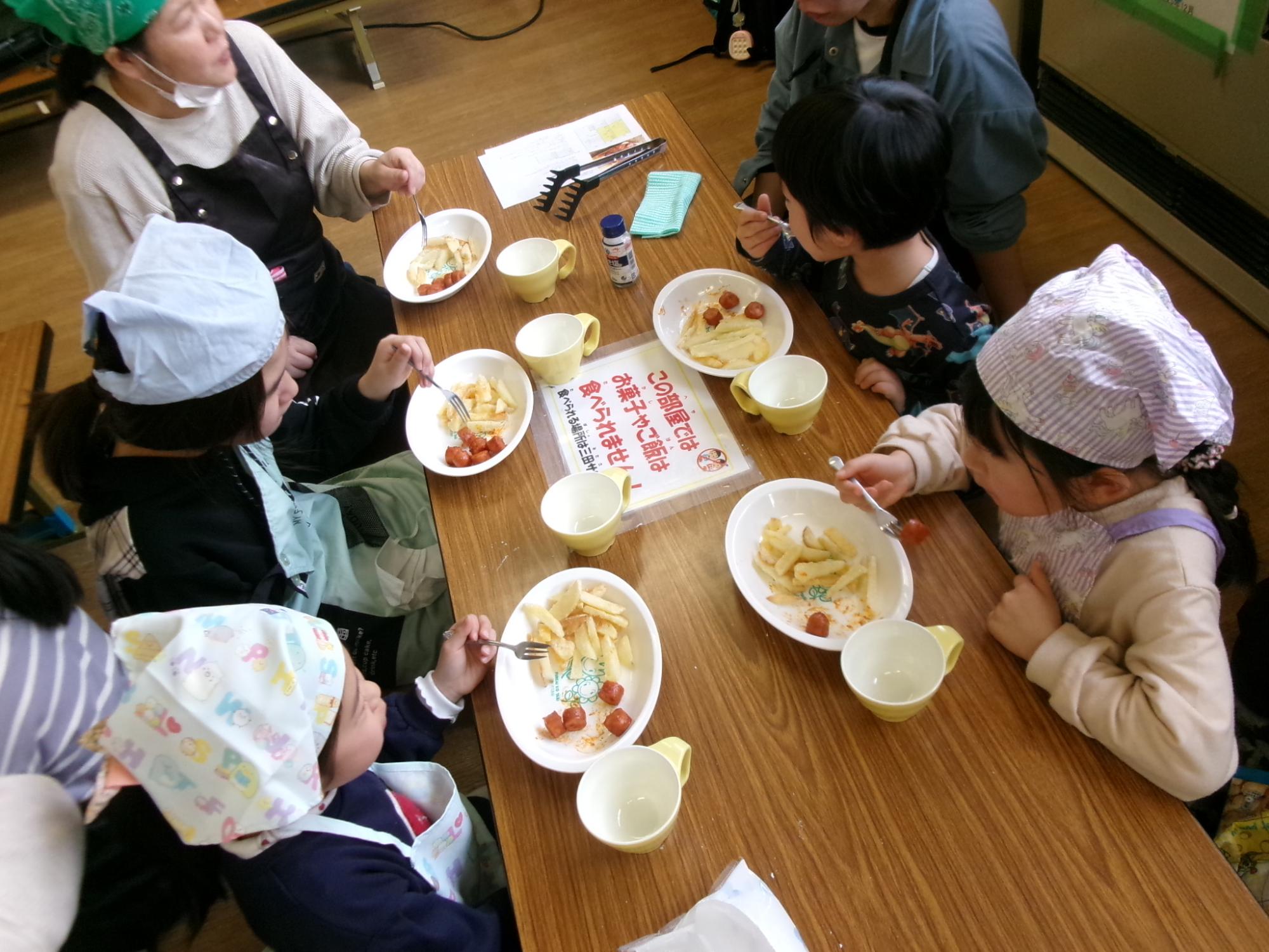 児童と地域住民が調理したドイツ料理を食べている様子