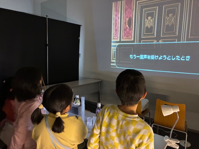 没入型の物語体験のプログラムを体験している子どもたちの写真