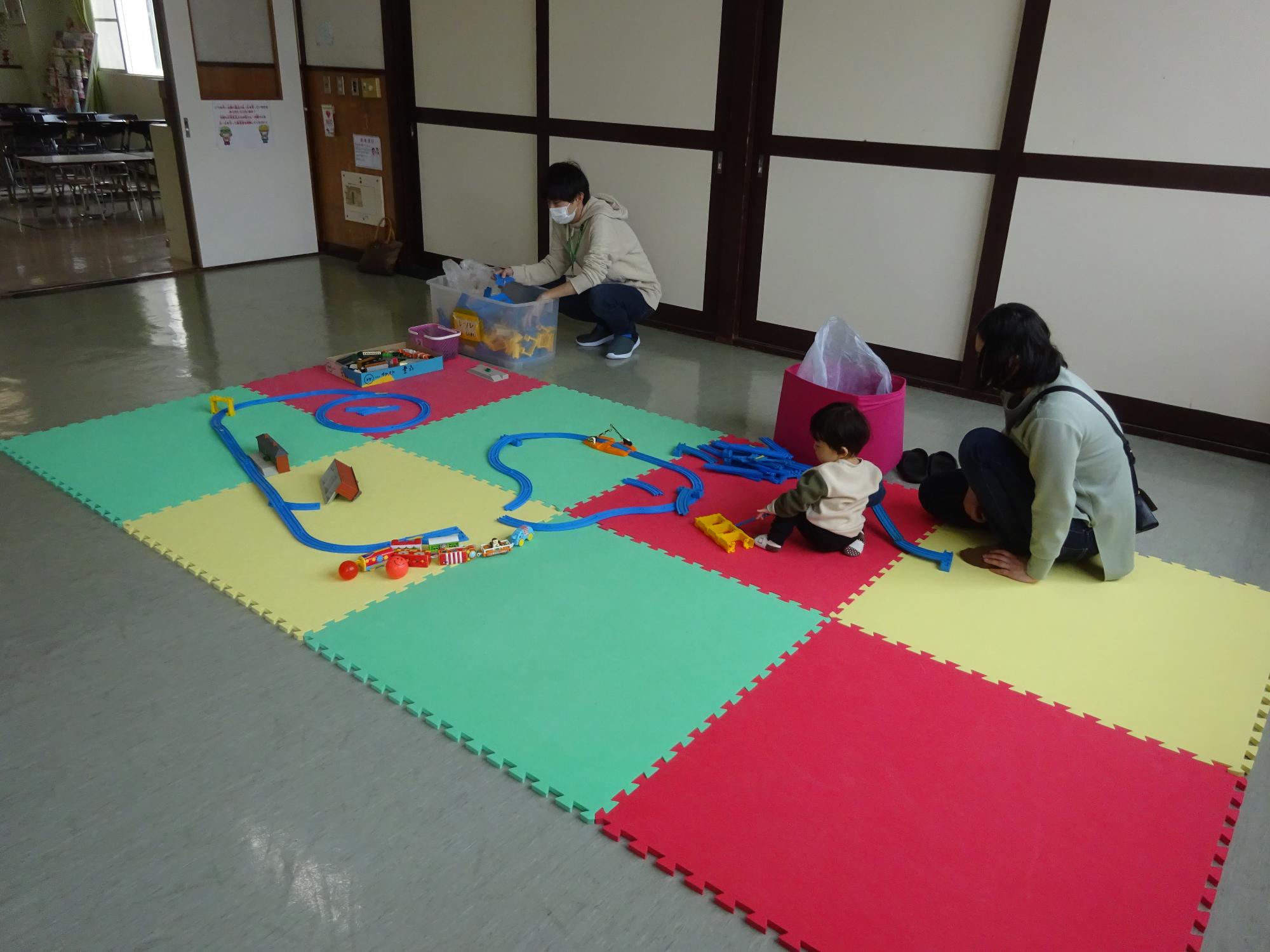 プラレールで遊ぶ幼児親子の写真