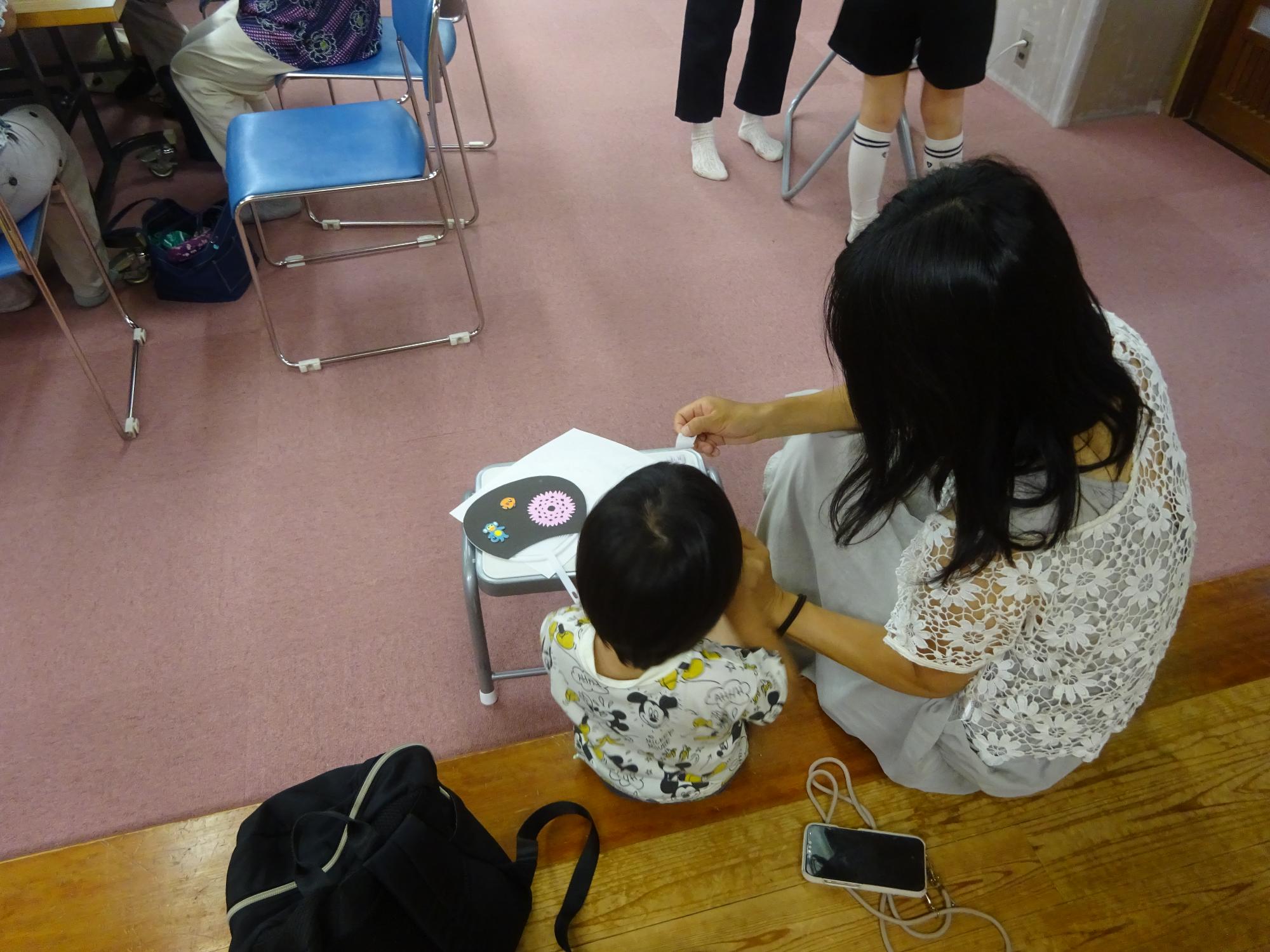 オリジナルうちわ作りをしている幼児親子の写真