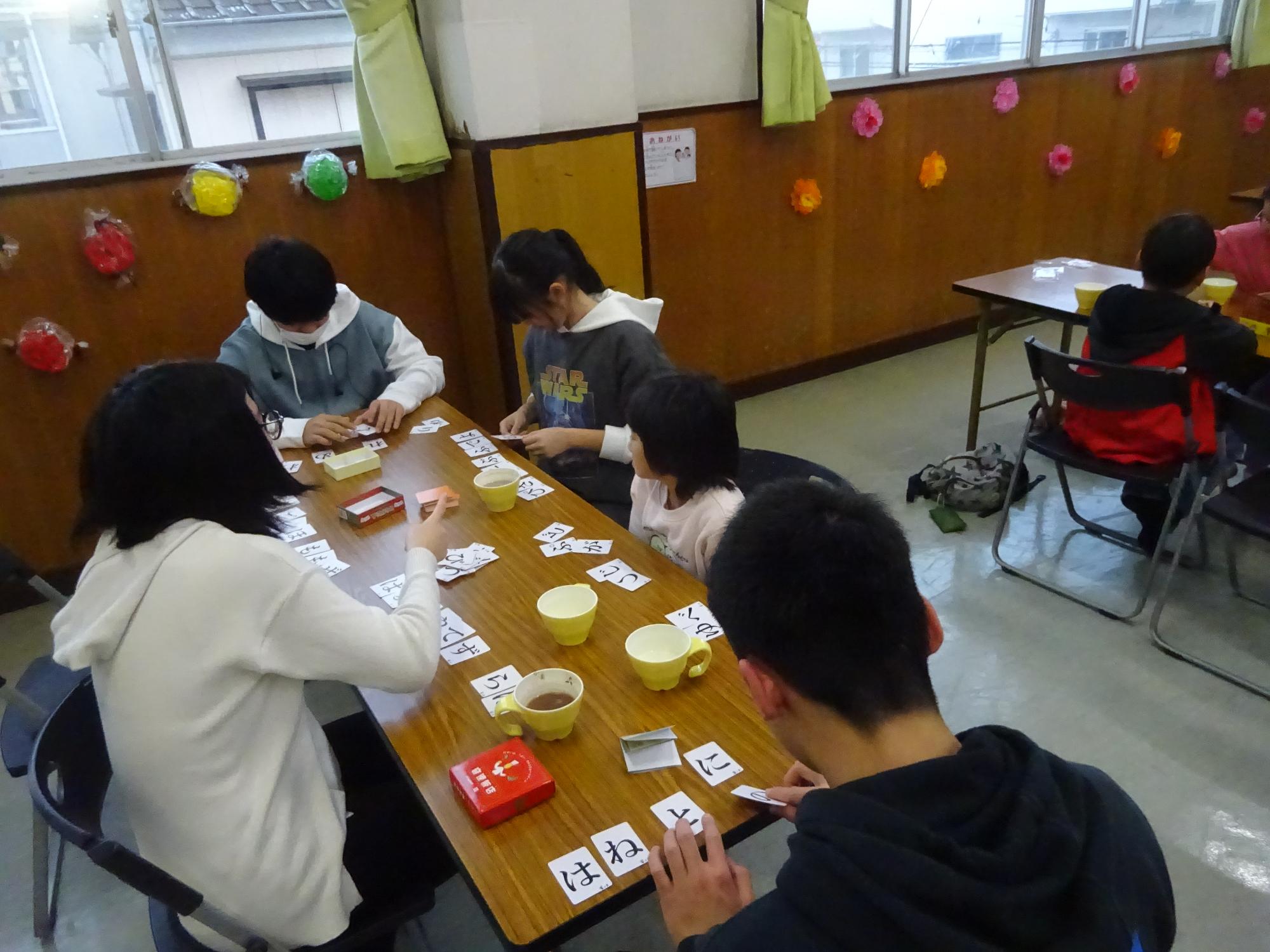 小学生と中学生が一緒にゲームを楽しんでいる写真
