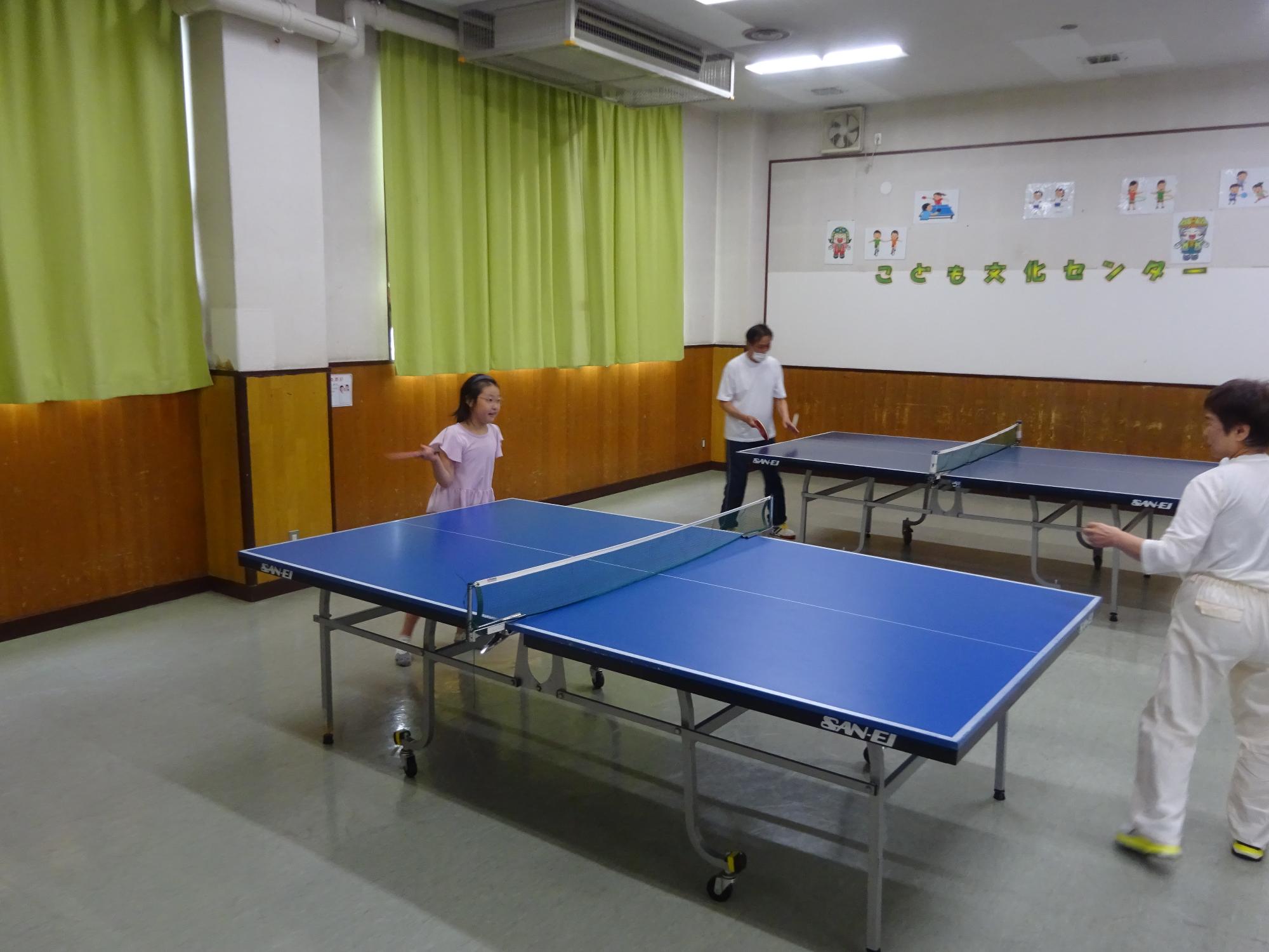 先生と卓球をする子どもの写真