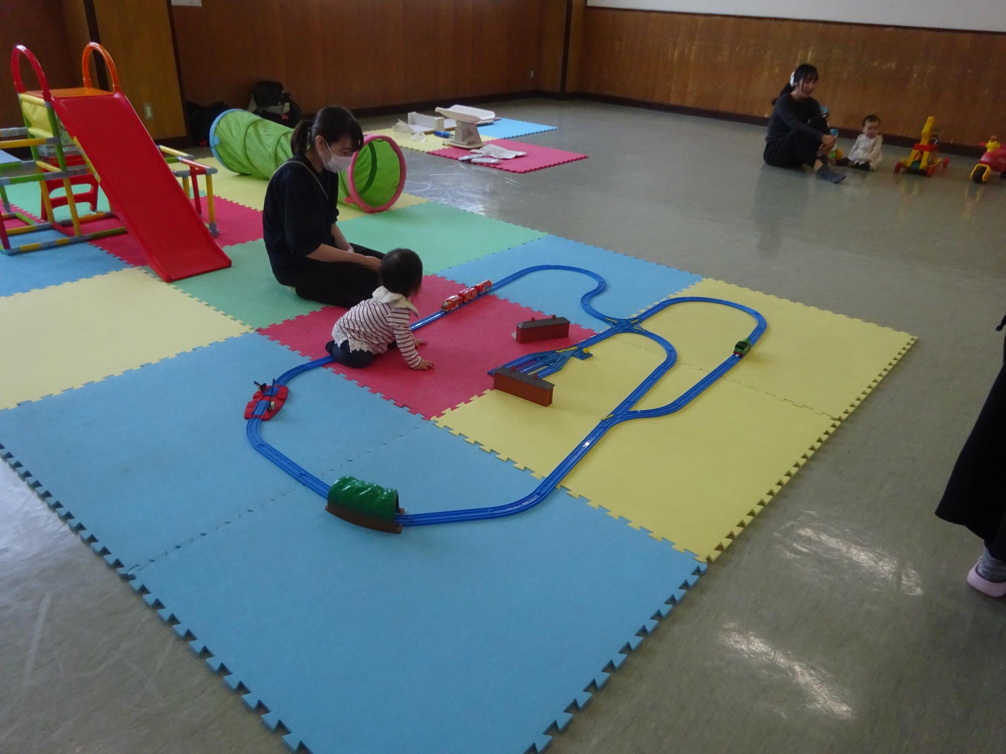 プラレールで遊ぶ幼児親子の写真