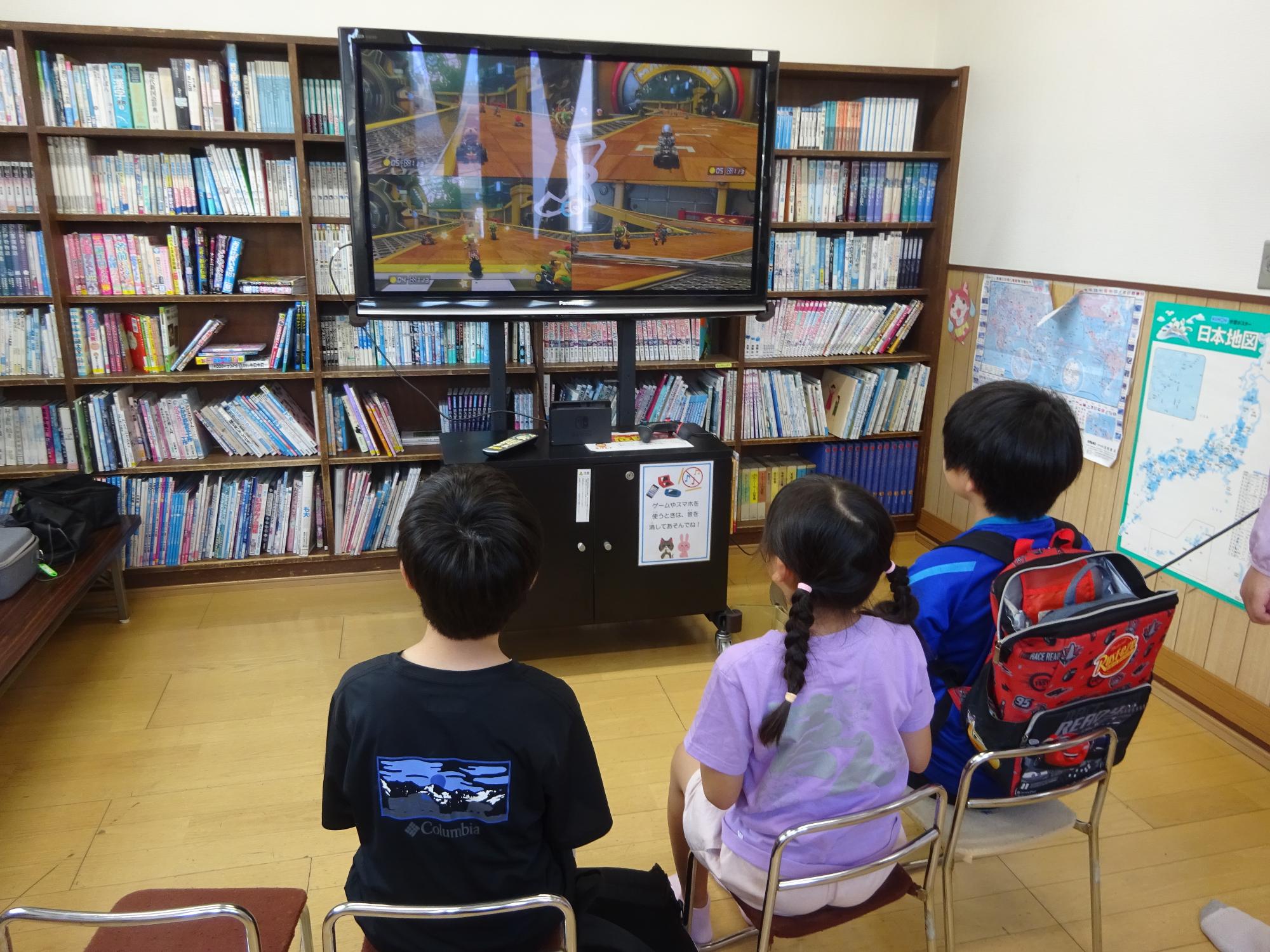 テレビゲームをする子どもたちの写真
