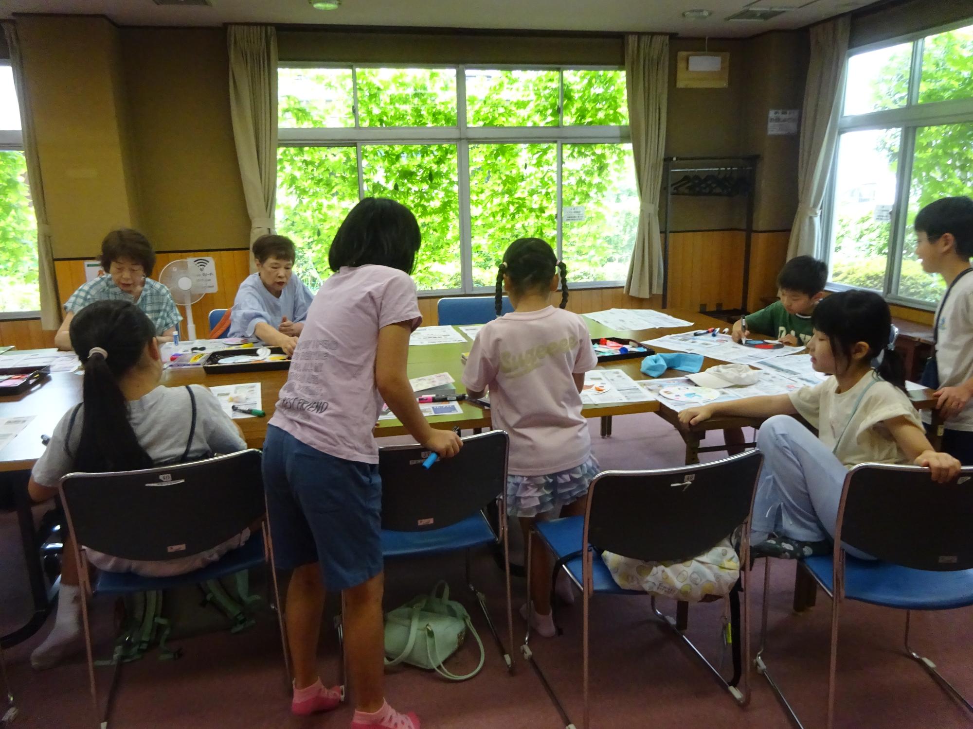 うちわ工作をする子ども達といこいの家の利用者