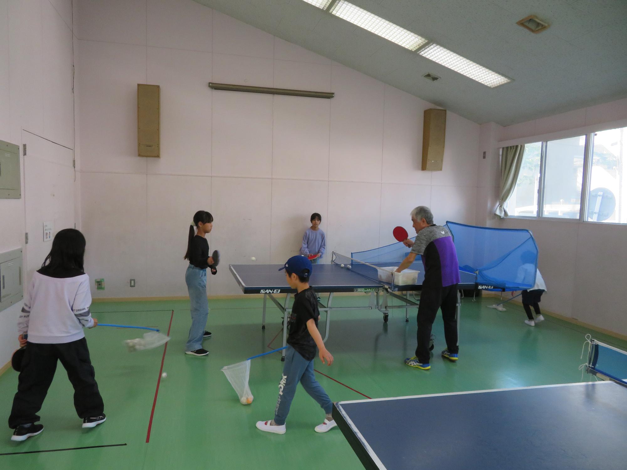 参加者が卓球の球を拾っている写真