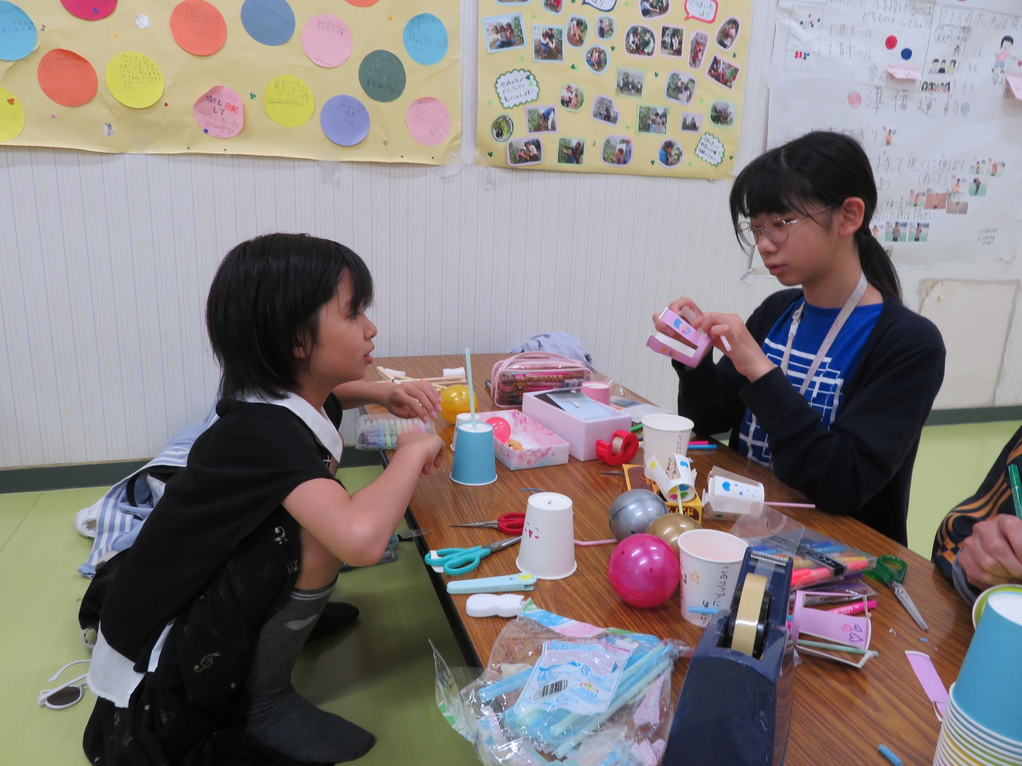 紙コップキャッチャーに好きなイラストを描いている小学生児童の写真