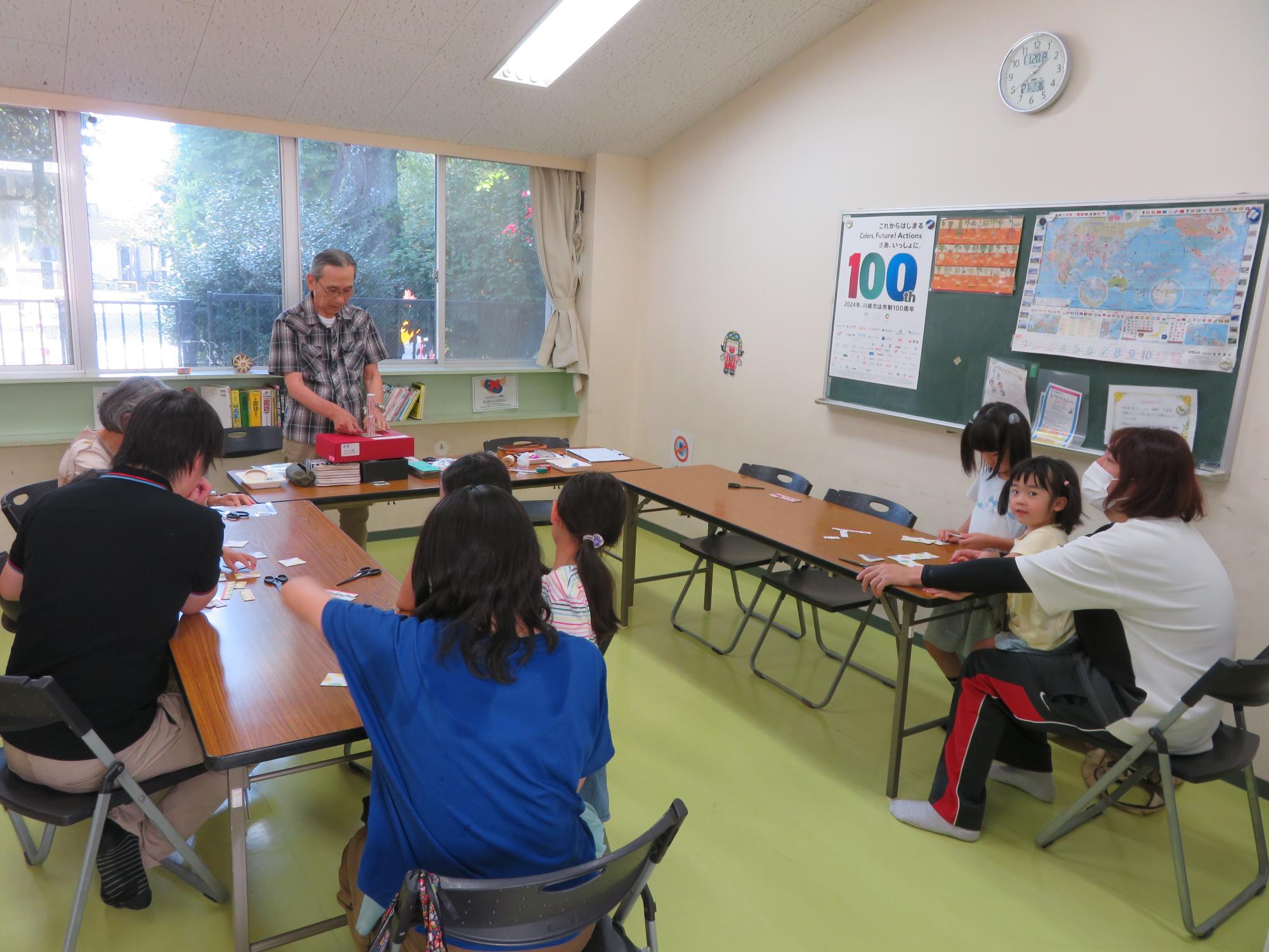 講師に今日の実験についての説明を受ける参加者の様子の写真