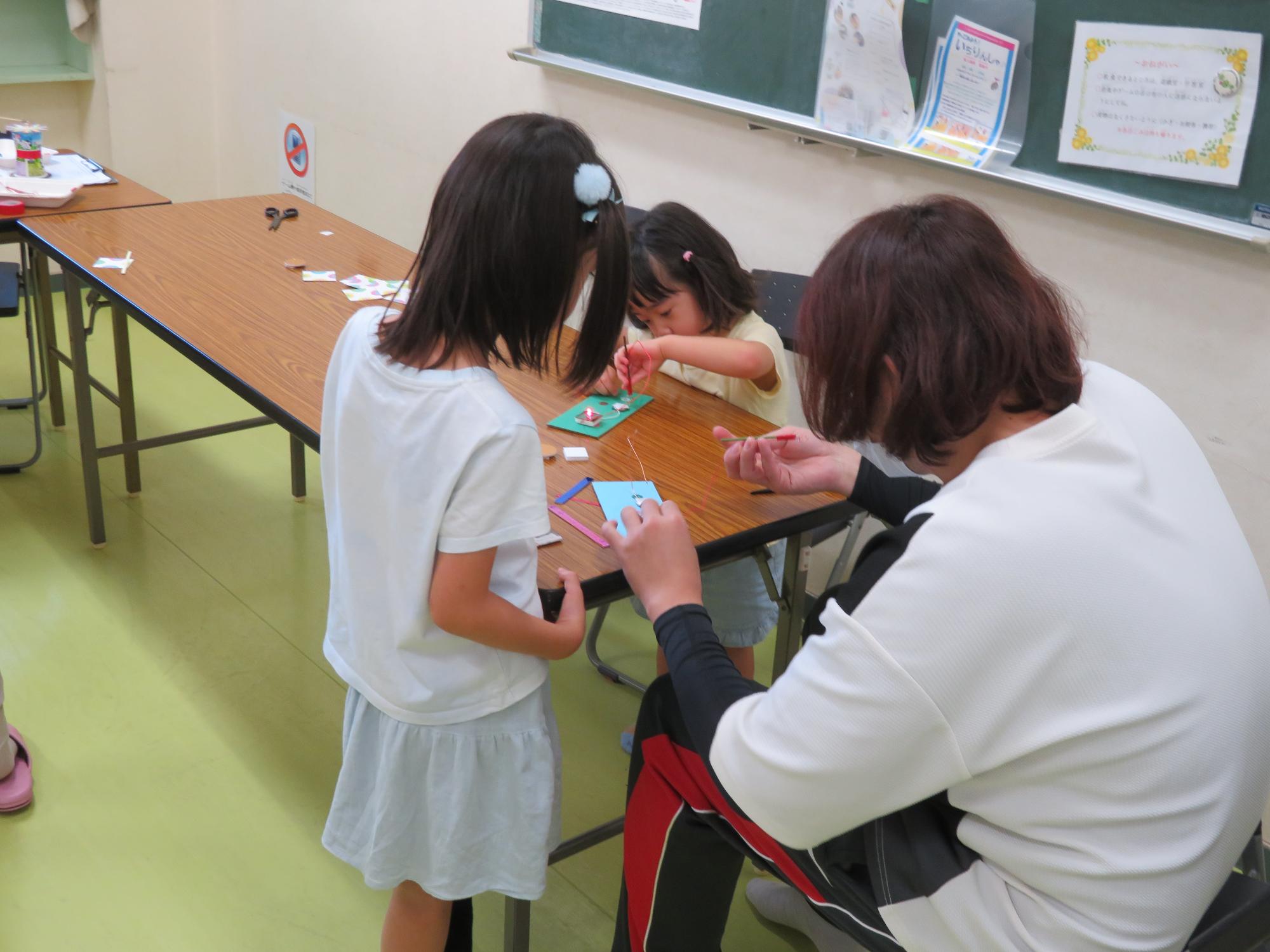 家族で作品づくりに取り組む参加者の様子の写真