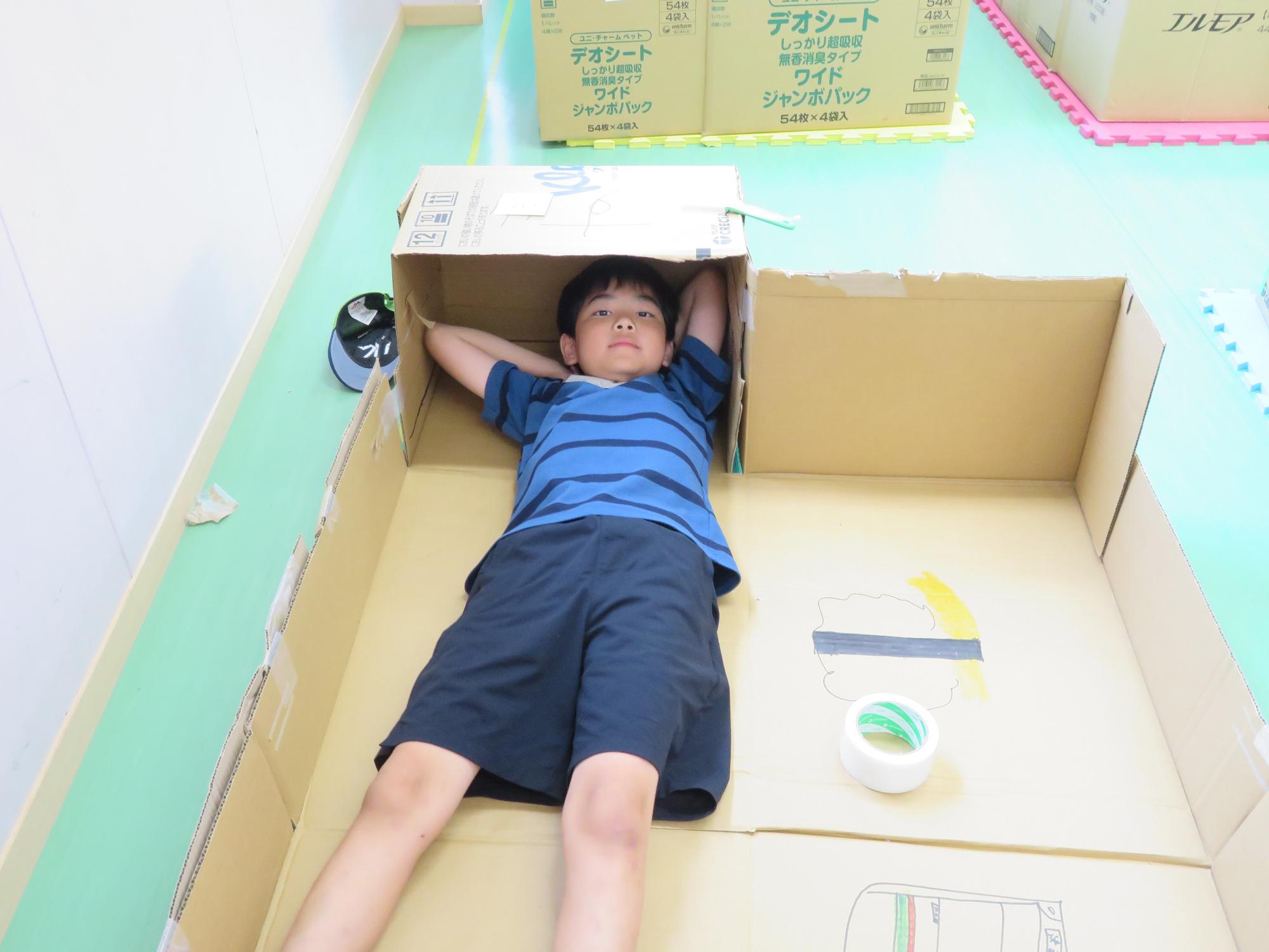 トレーニング室でダンボールハウスを作っている写真