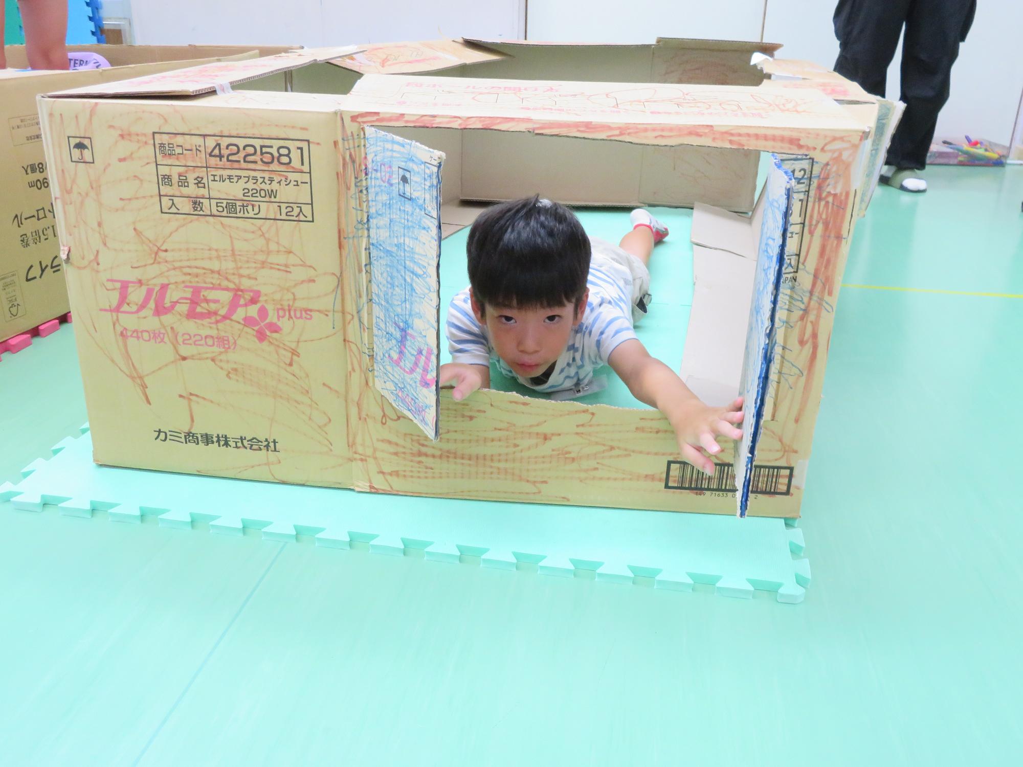 トレーニング室でダンボールハウスを作っている写真