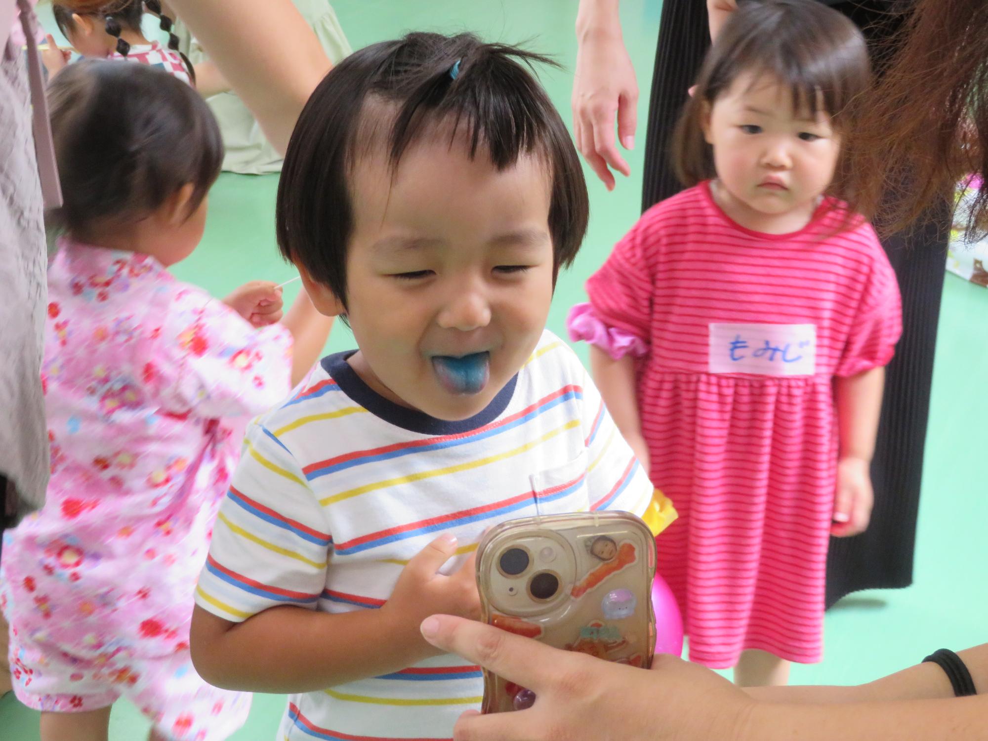 かき氷を食べた舌を見せてくれている幼児の写真
