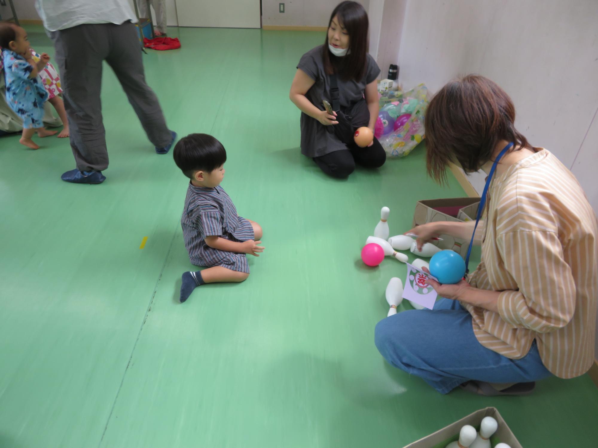 ボーリングで遊ぶ幼児親子の様子の写真