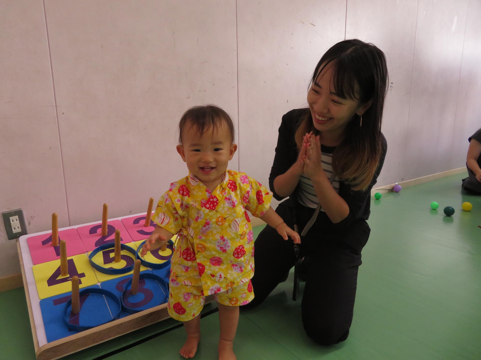 わなげで遊ぶ乳幼児親子の様子の写真