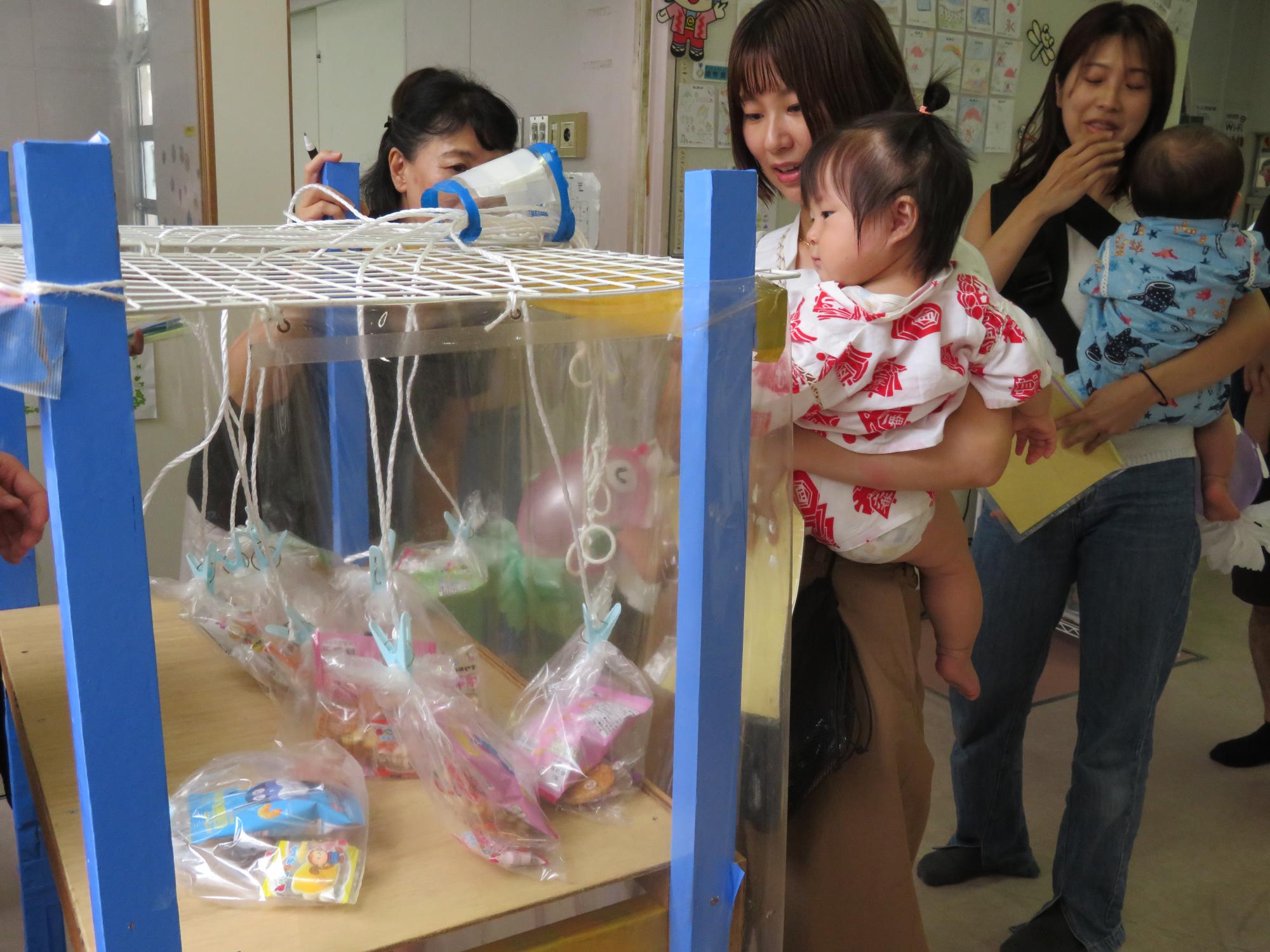 引きくじに挑戦する幼児親子の様子の写真