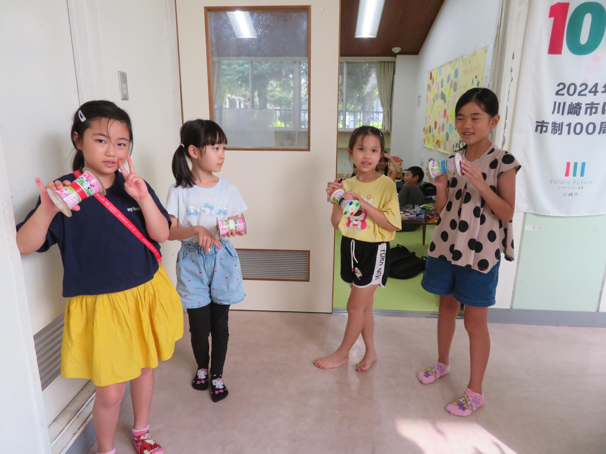 自分の作った作品と一緒に写真を撮る小学生児童の写真