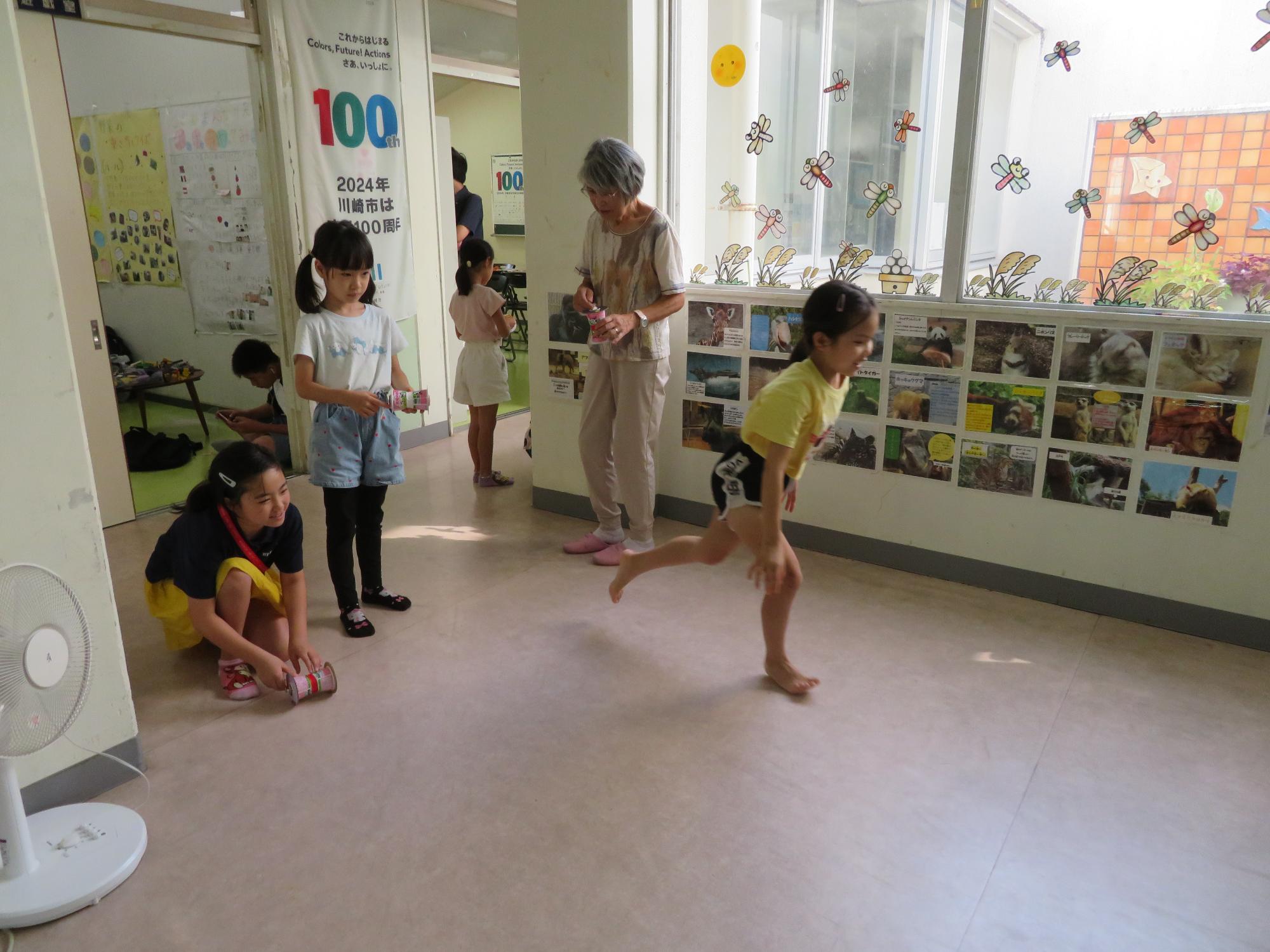 自分の作った作品で遊ぶ小学生児童の様子の写真