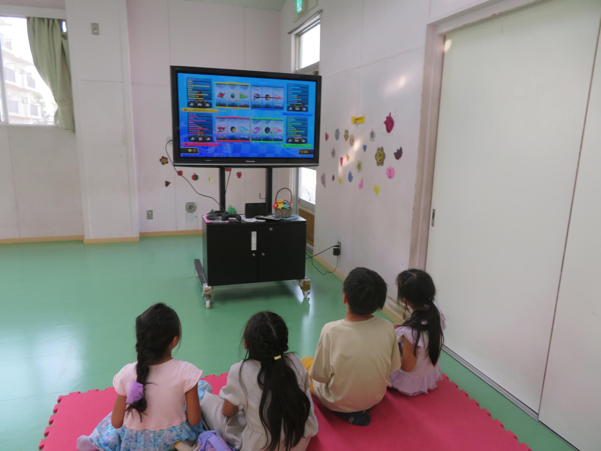 トレーニング室でテレビゲームで遊ぶ小学生児童の写真