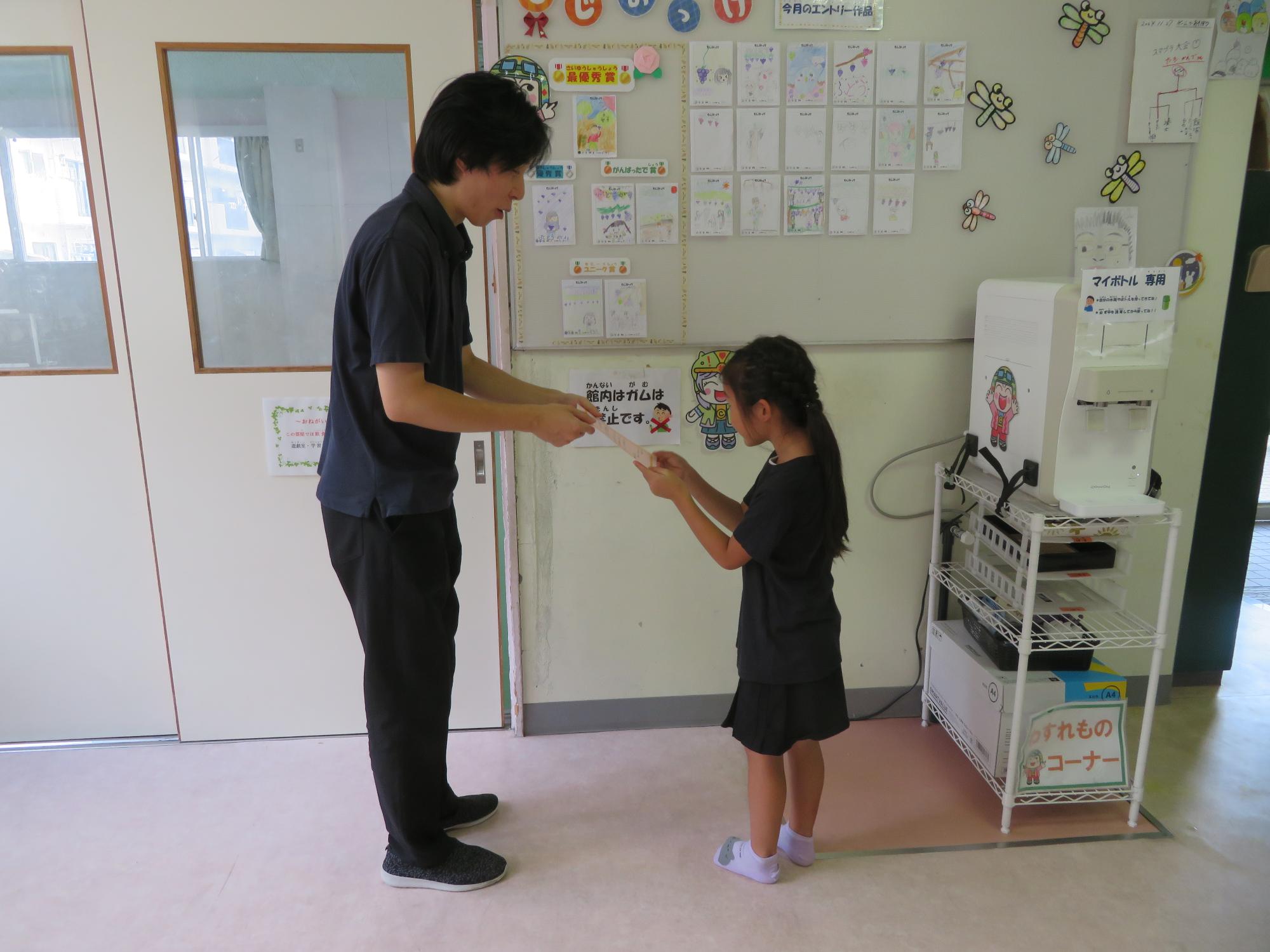 9月の「もじみっけ」で賞を獲った児童が職員より表彰される様子の写真